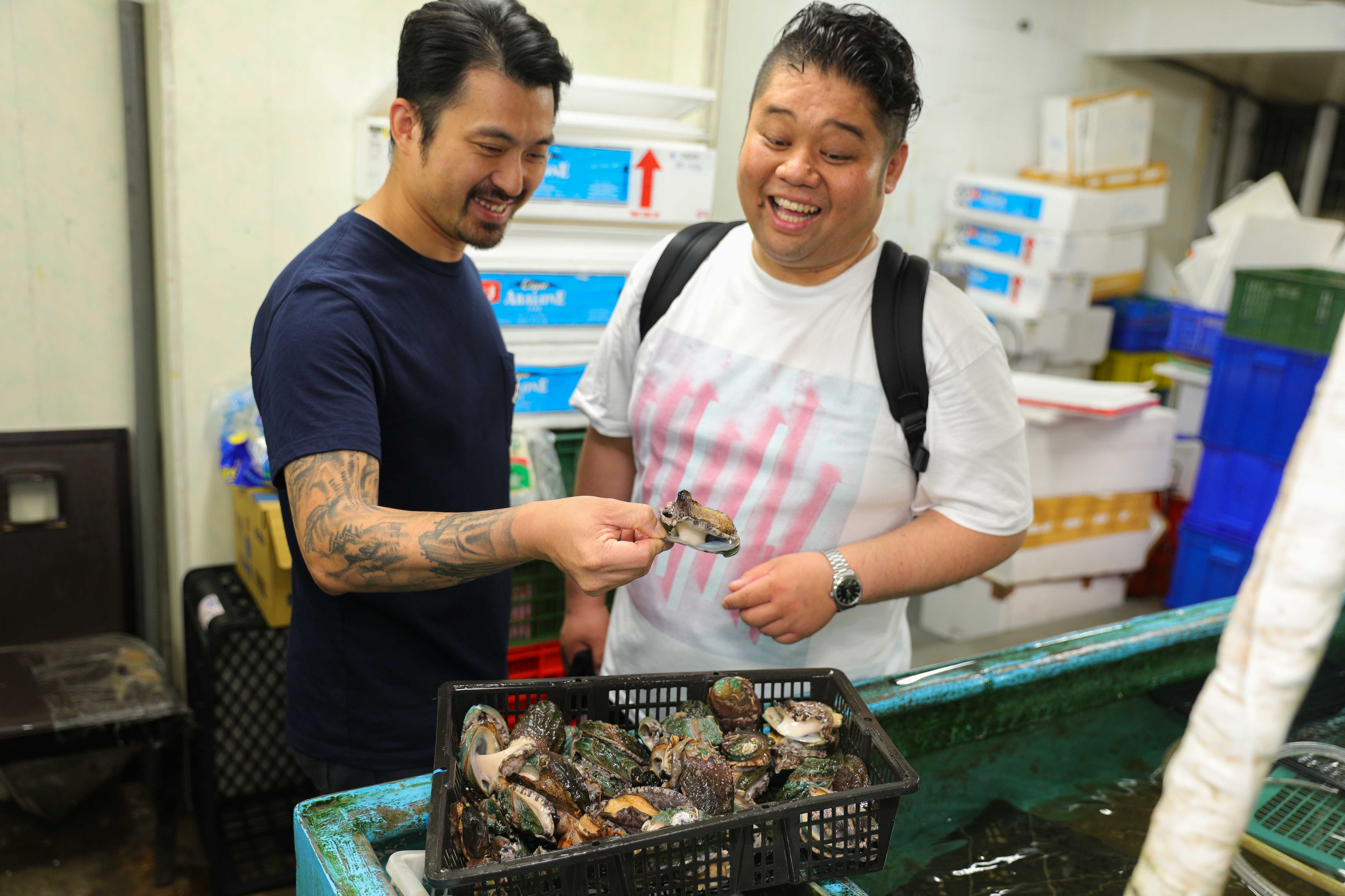 「Chou Chou法式料理餐廳」主廚林明健（左）介紹台灣的九孔鮑給東京米其林二星餐廳「Hommage」主廚荒井昇（右）。
