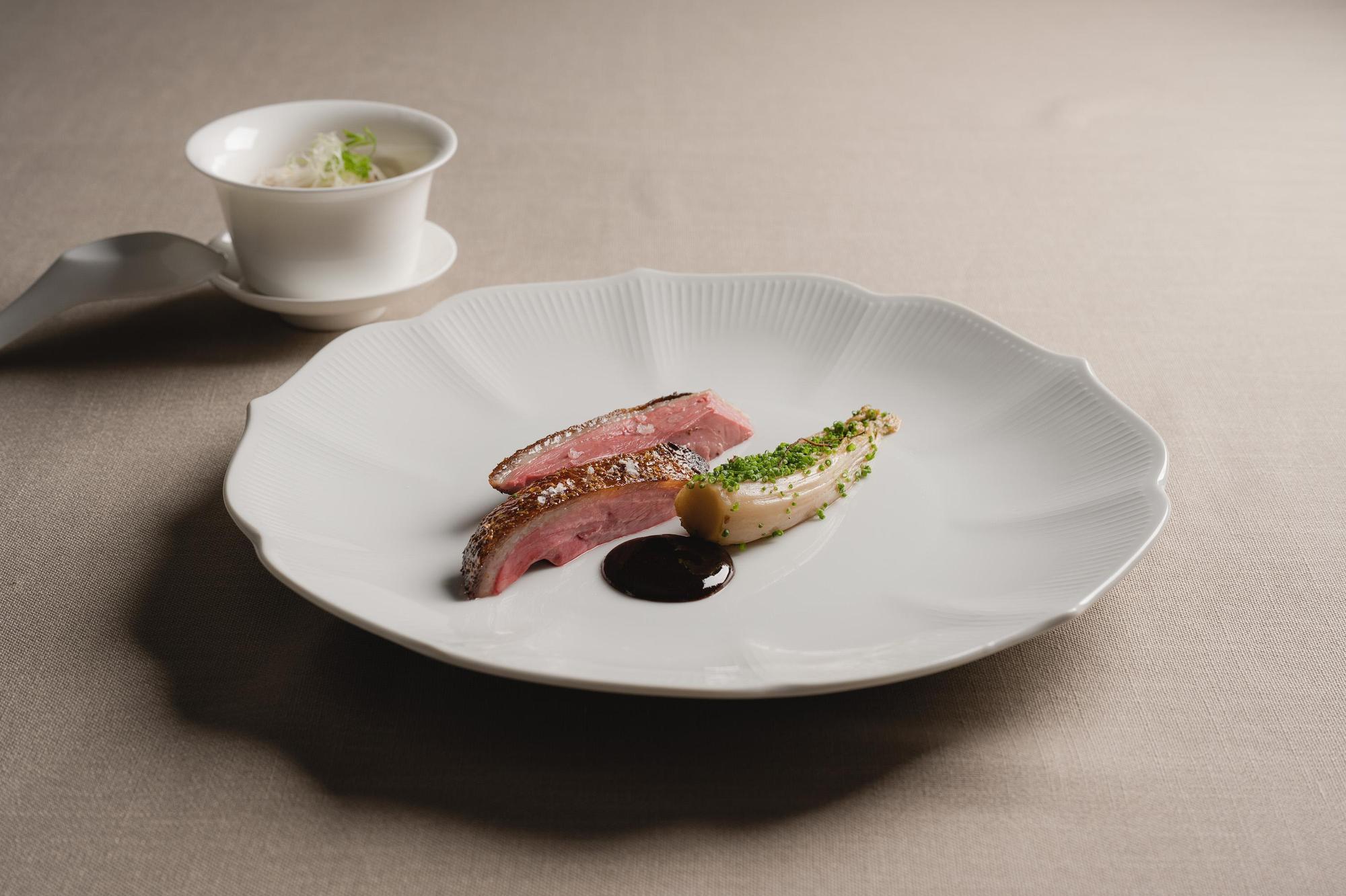 Chou Chou新菜「爐烤乾式熟成胭脂鴨胸」運用港式烤鴨手法,搭配娃娃菜,烏梅醬和小米粥。(Chou Chou法式料理餐廳提供)