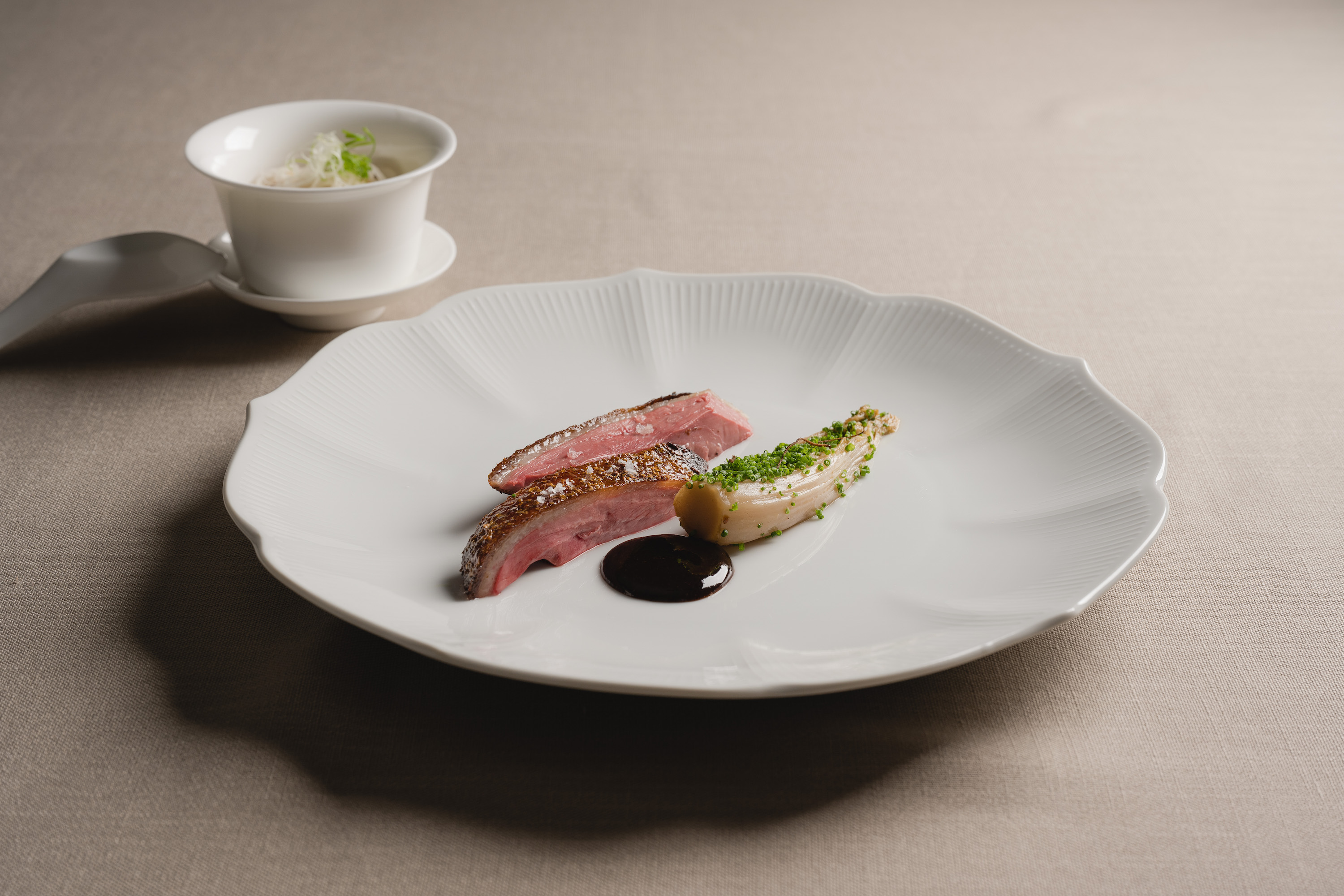 Chou Chou新菜「爐烤乾式熟成胭脂鴨胸」運用港式烤鴨手法，搭配娃娃菜，烏梅醬和小米粥。（Chou Chou法式料理餐廳提供）