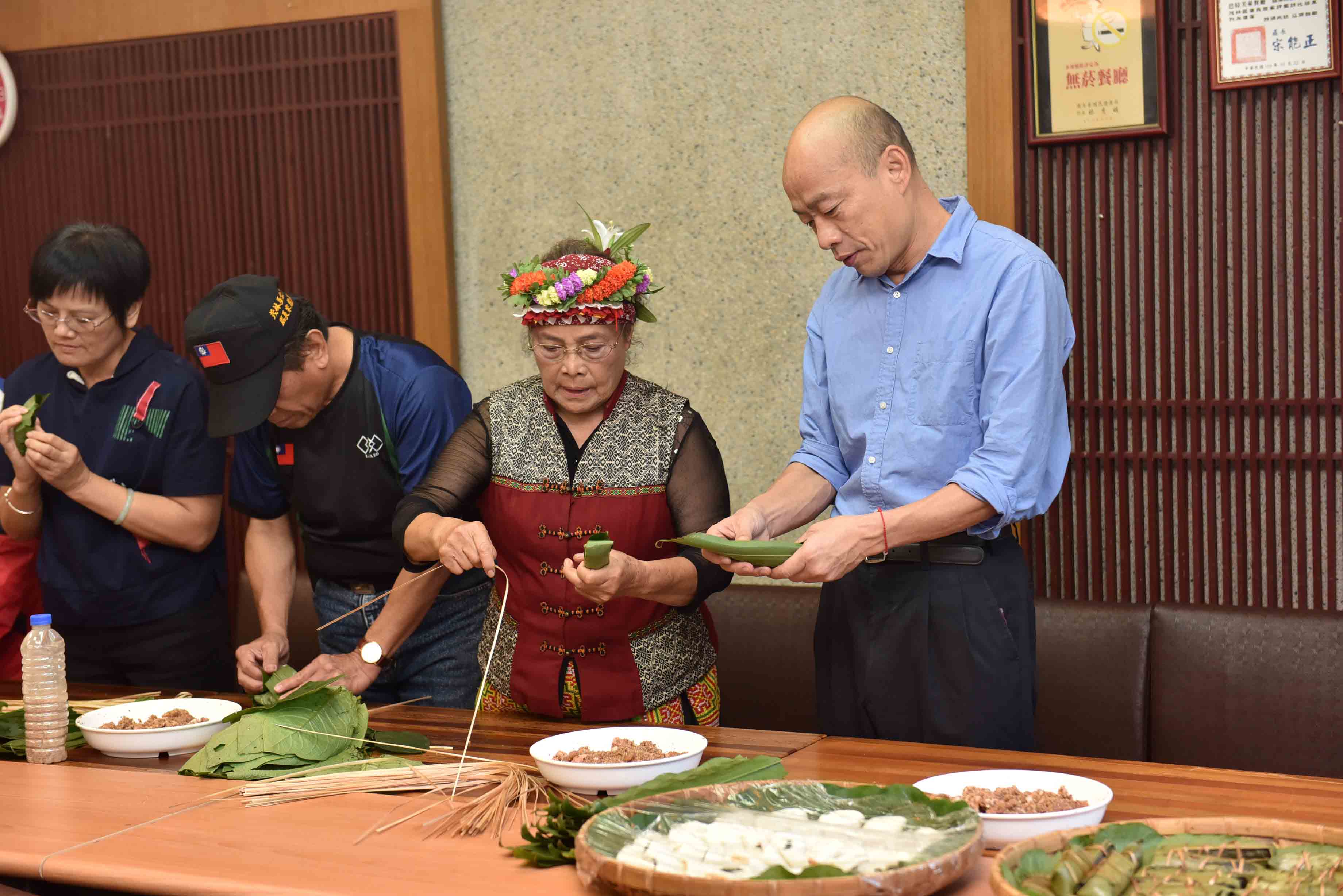 韓國瑜體驗手做原住民美食「吉那富」。（高市府提供）