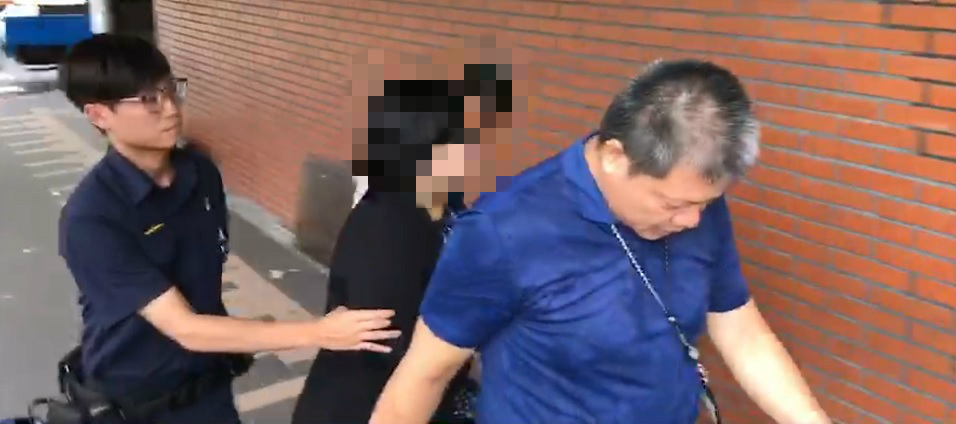 新北勞工局王姓女職員持預藏尖刀砍殺副局長未遂後,遭警制伏並送海山警分局偵辦。(翻攝畫面)