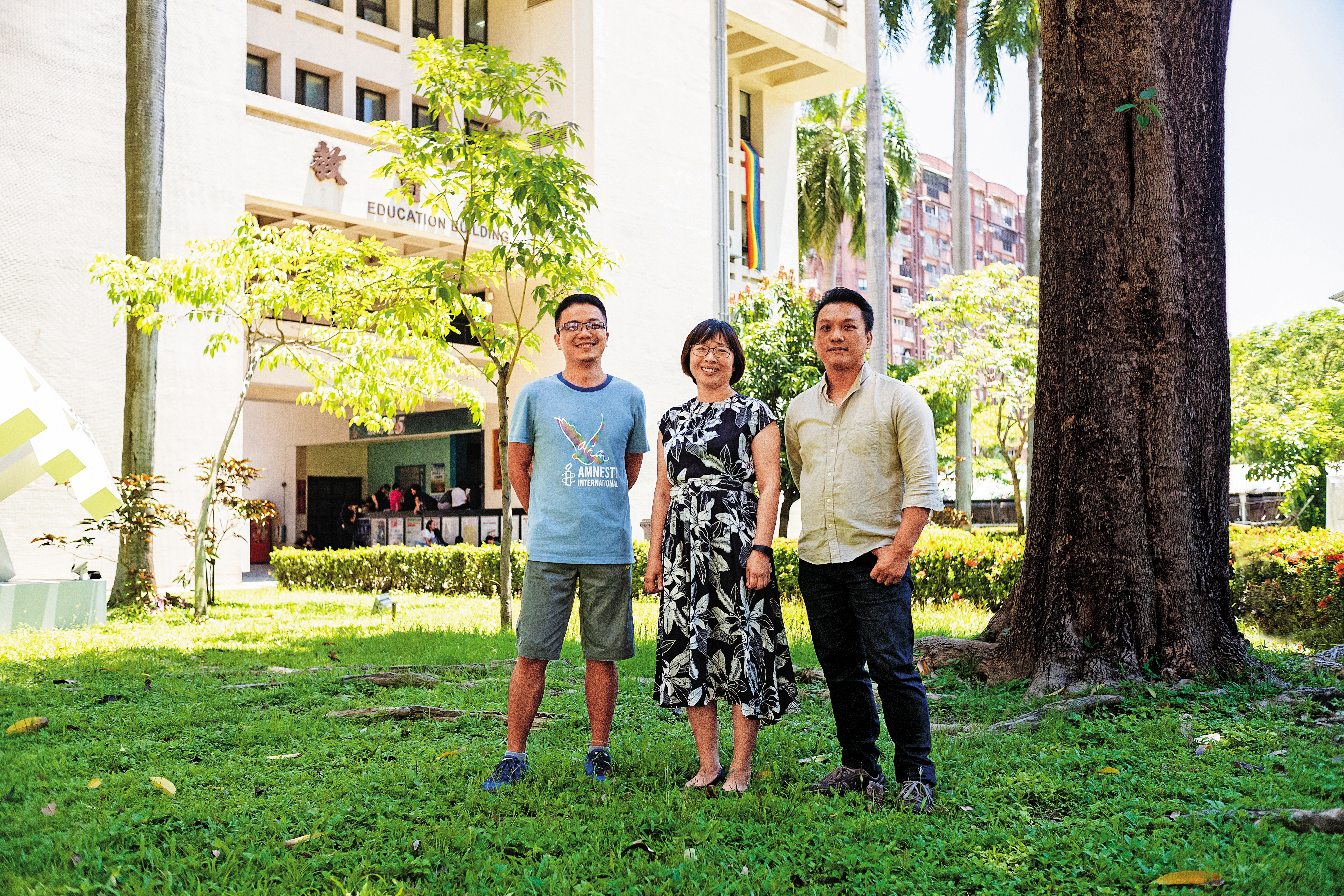 劉育豪（左起）、洪菊吟與達努巴克長期推動性別平等教育，3人在年度研習會上碰面，後方大樓正巧高掛彩虹旗。