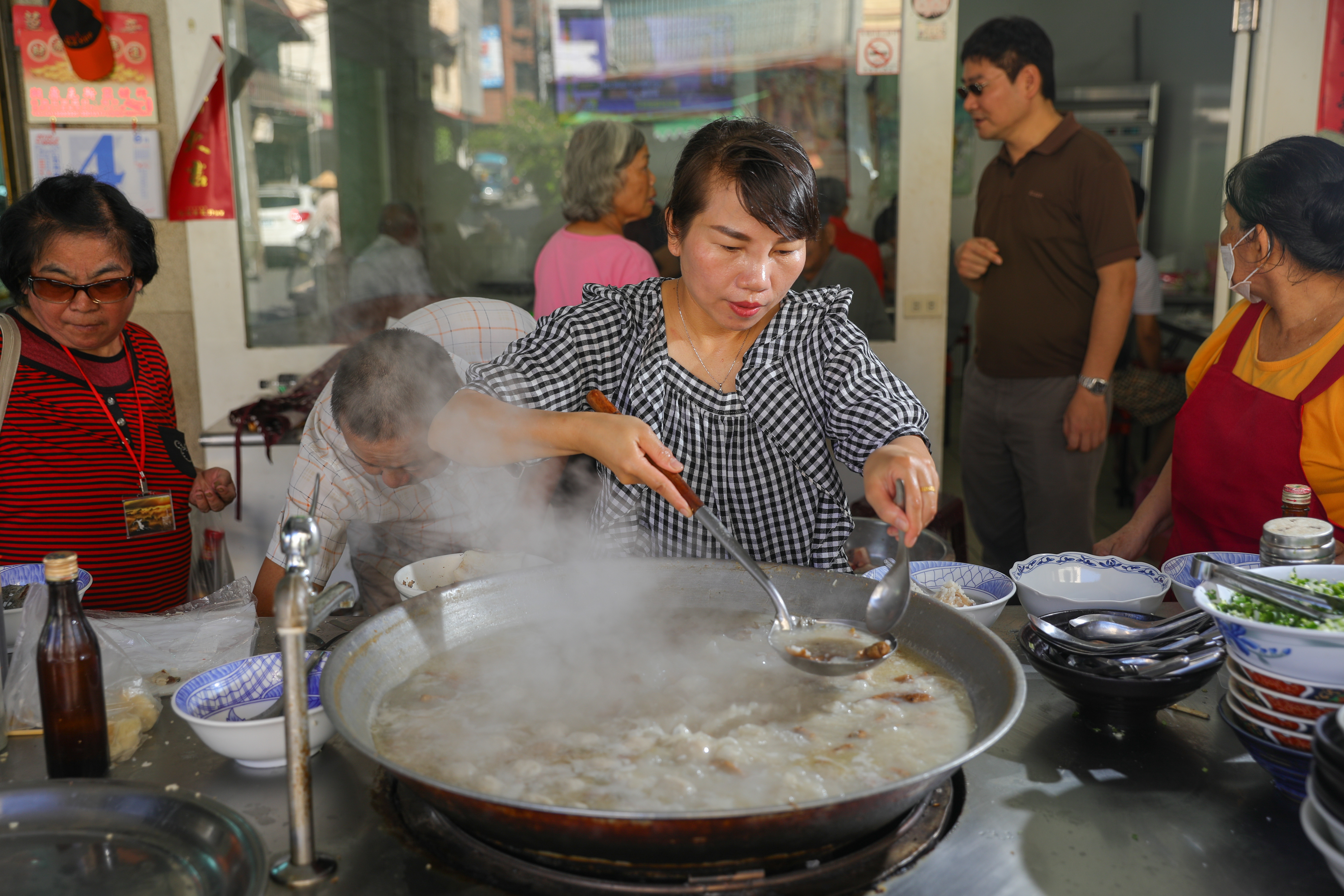 「白河草魚粥」一早熱湯滾滾、白煙蒸騰，老闆娘鄧秋菊忙得沒空放下手中的大湯杓。