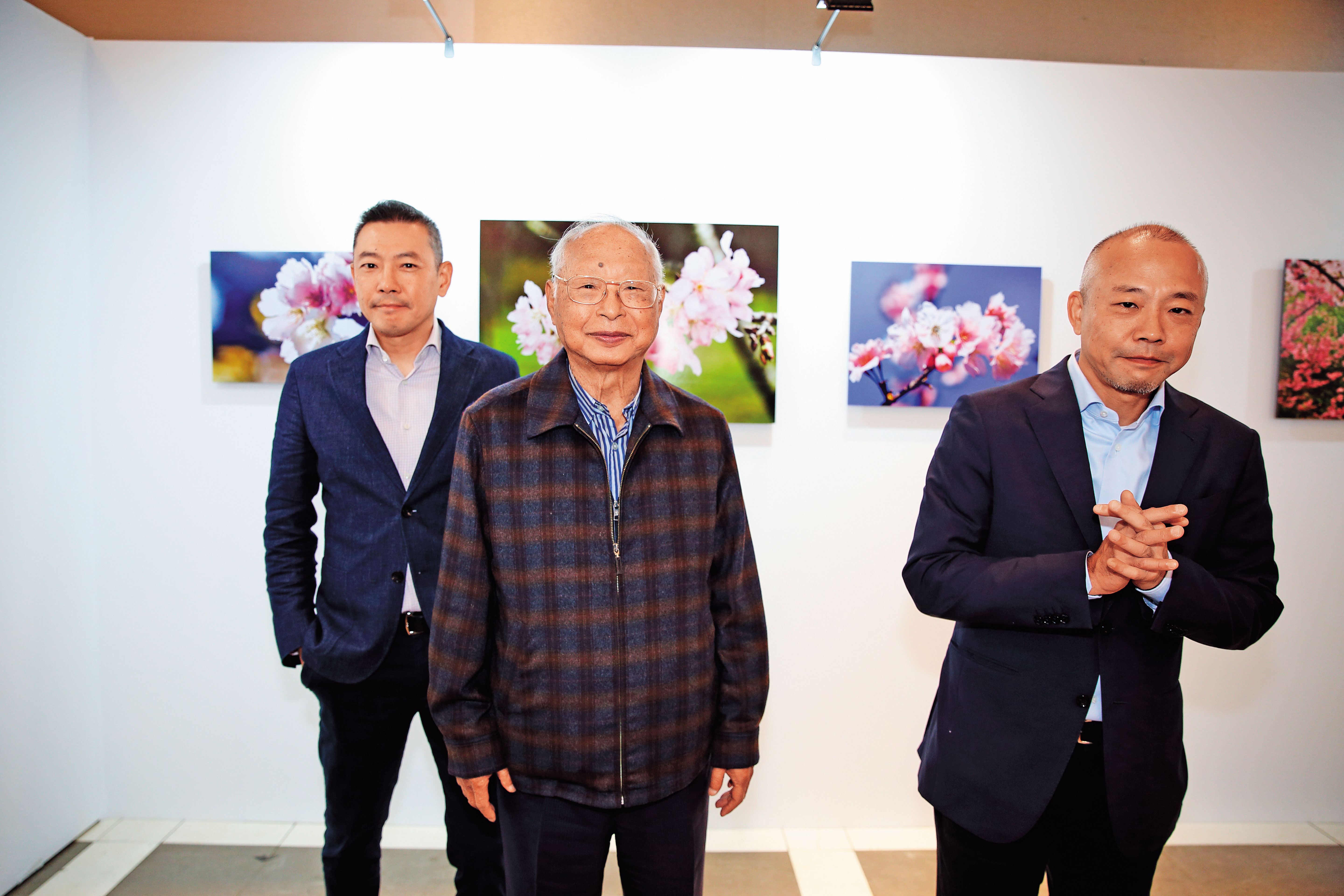 吳東興(中)為保經營權,把長子吳昕達(右)從總經理位子換下,改派次子吳昕陽(左)。圖為父子3人出席新光三越攝影展。