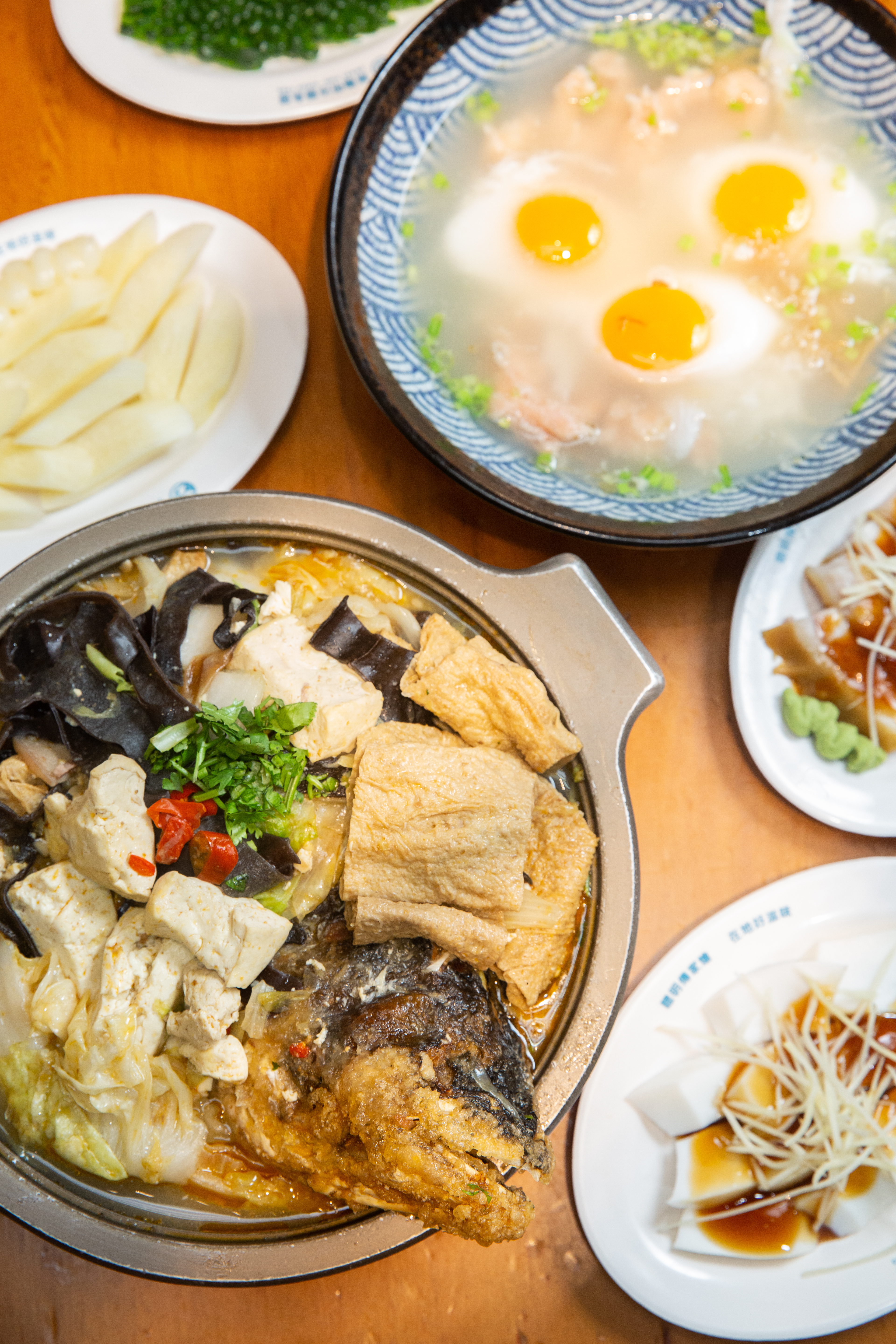林聰明的招牌料理砂鍋魚頭（前排），是江中琇的最愛。（490元／鍋）