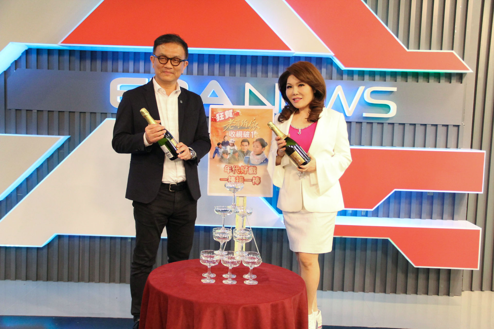《老有所依》收視屢創新高，年代主播張雅琴（右）與年代董事長特助陳斯維開香檳慶祝。（年代提供）