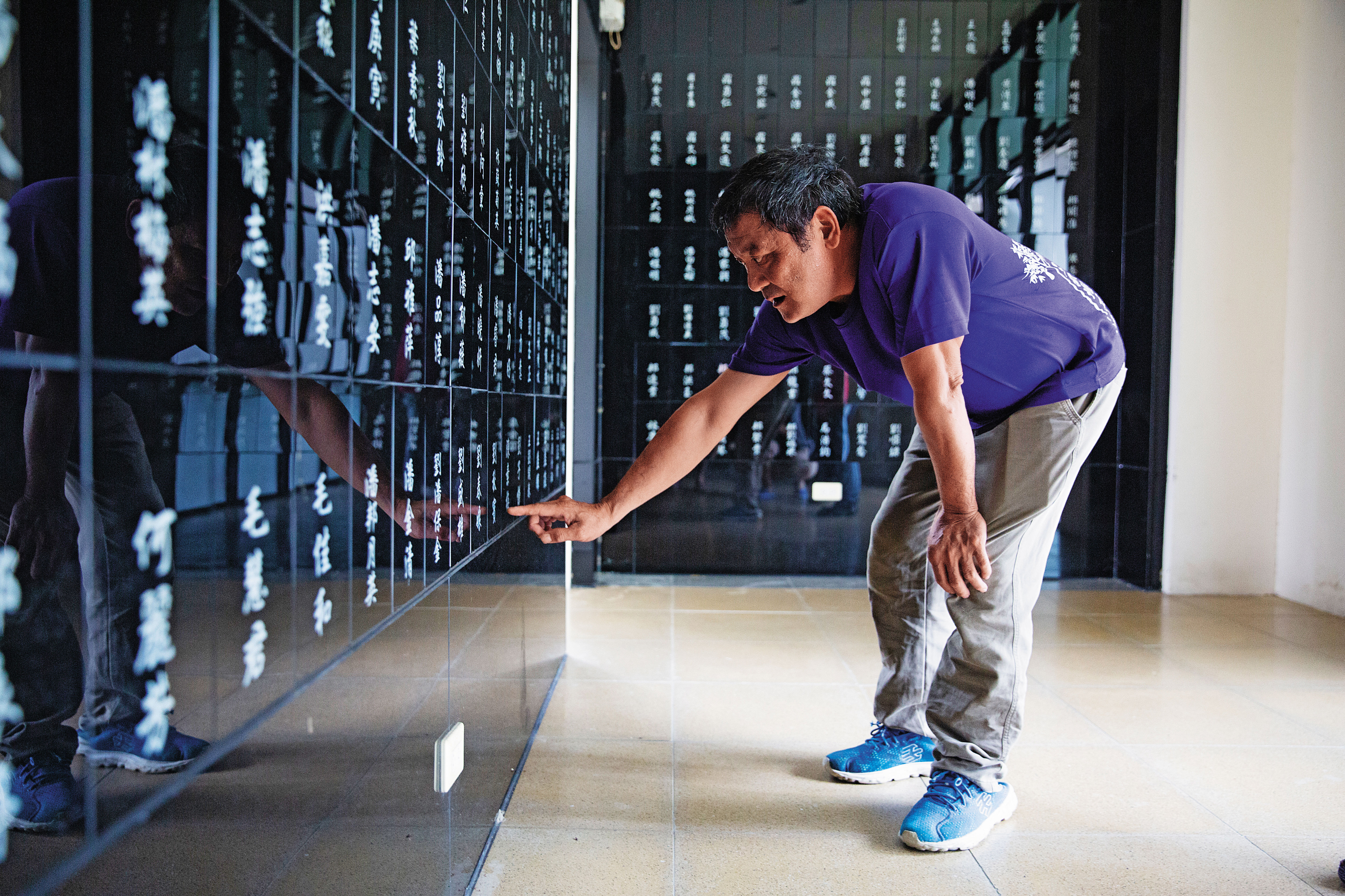 劉秋田靜靜指著小林公祠內阿嬤、父母、弟弟與弟媳的名字。