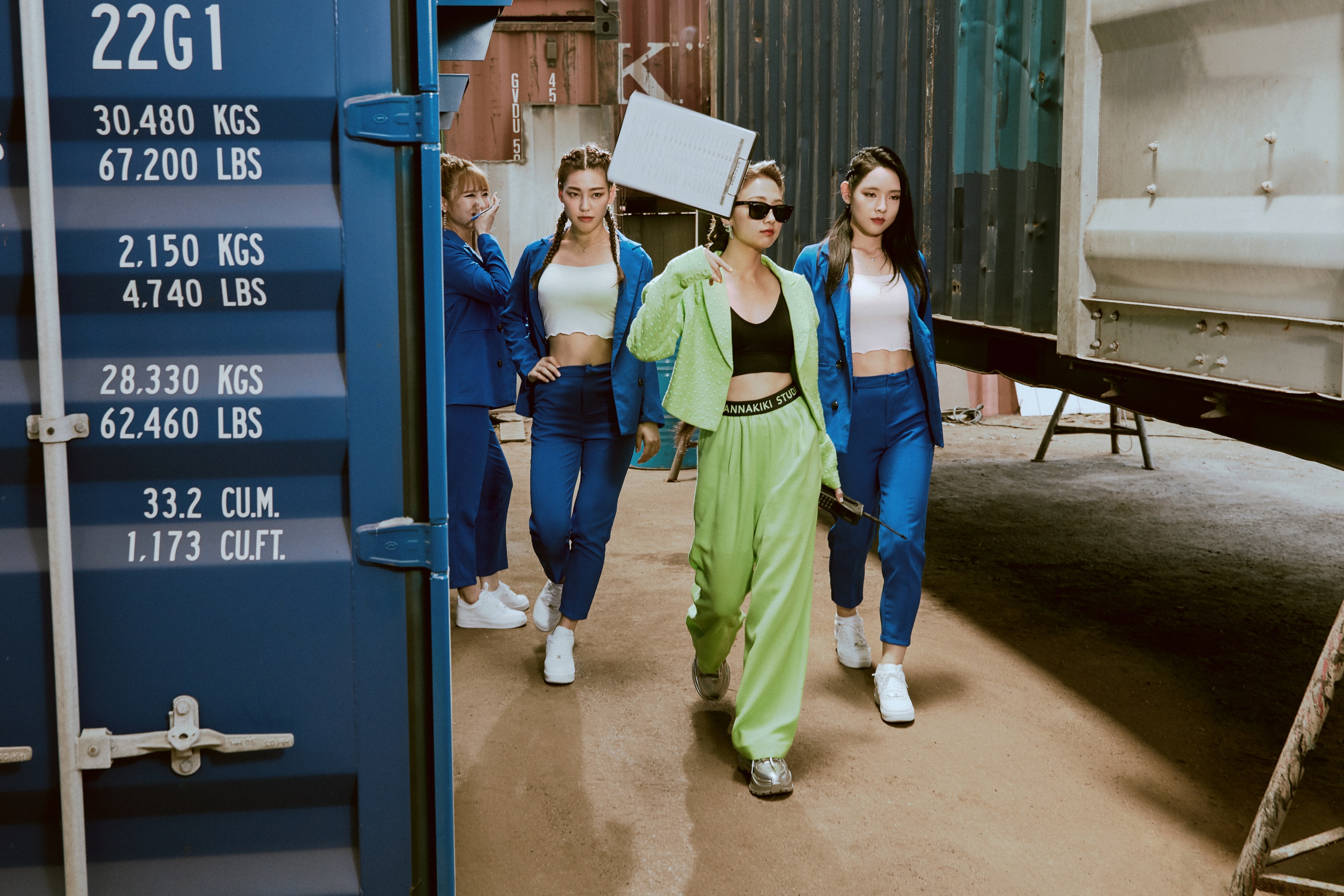 鬼鬼在〈啦咪啦咪〉MV中，換上半截式運動套裝，秀出水蛇腰、外面套上鮮綠色大衣及墨鏡形象的造型，充滿黑道女王的氣勢。（吳映潔工作室提供）