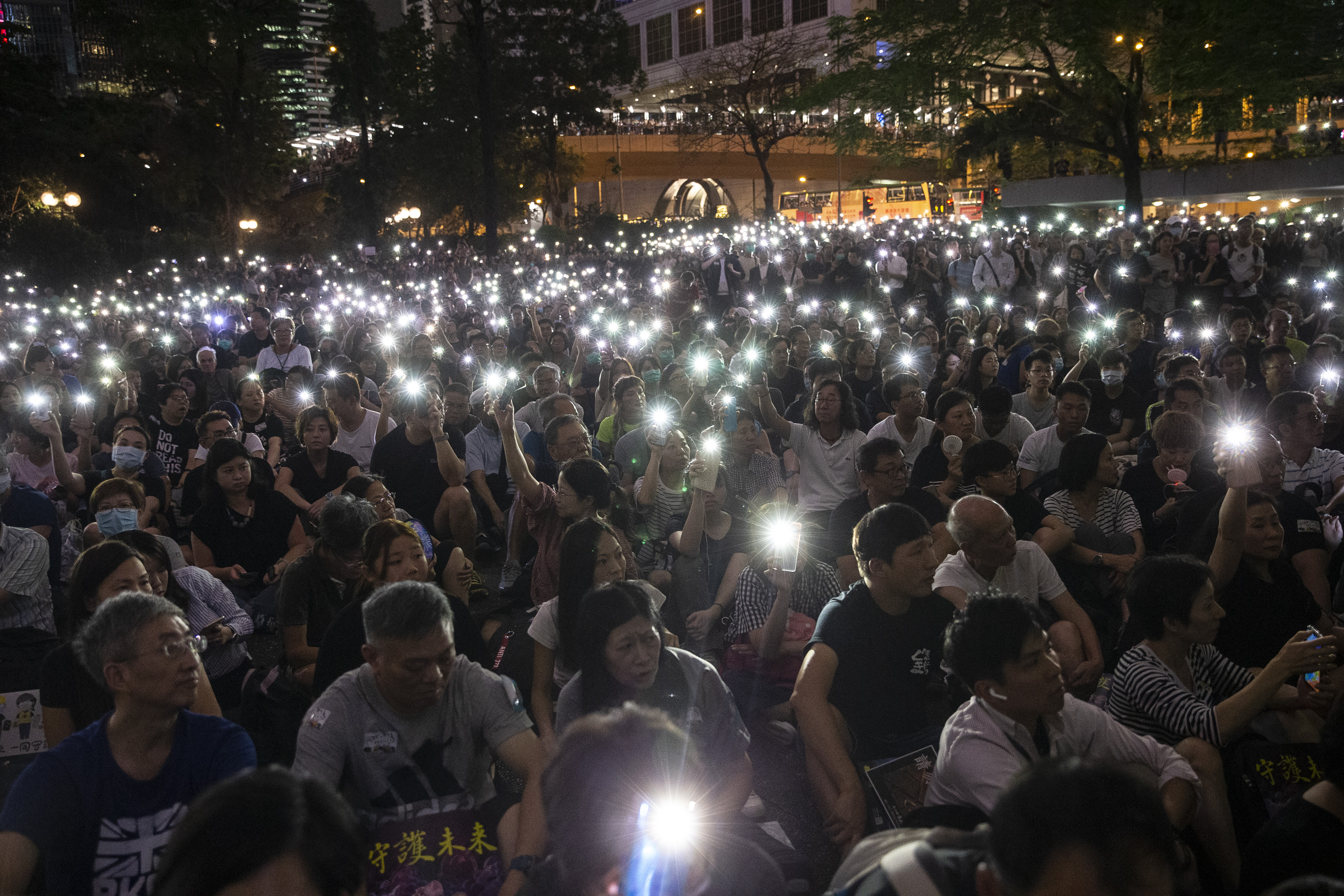 出席的香港公務員高舉亮起的手機，形成一片燈海。