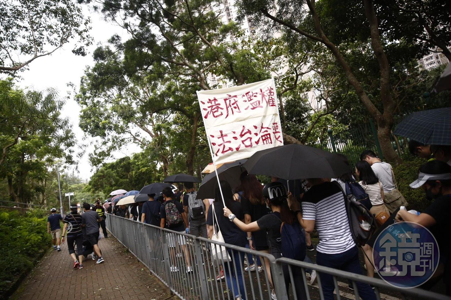 民眾身穿黑衣高舉口號,質疑港府濫權、法治淪喪。