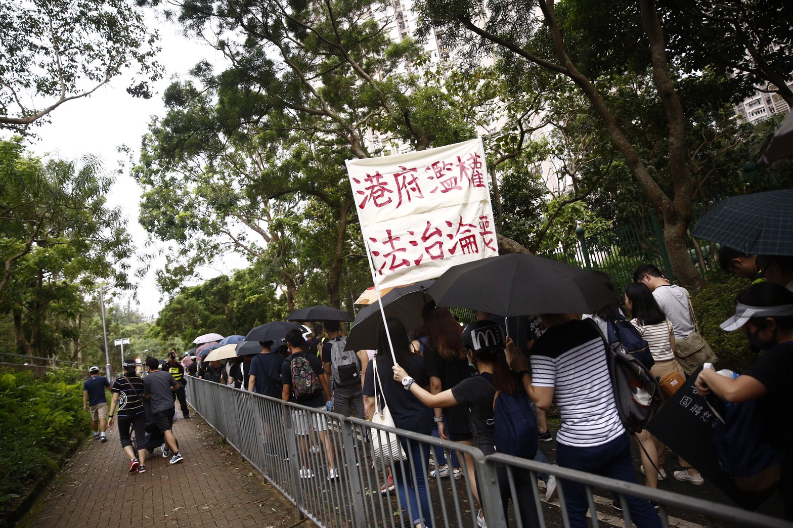 民眾身穿黑衣高舉口號,質疑港府濫權、法治淪喪。