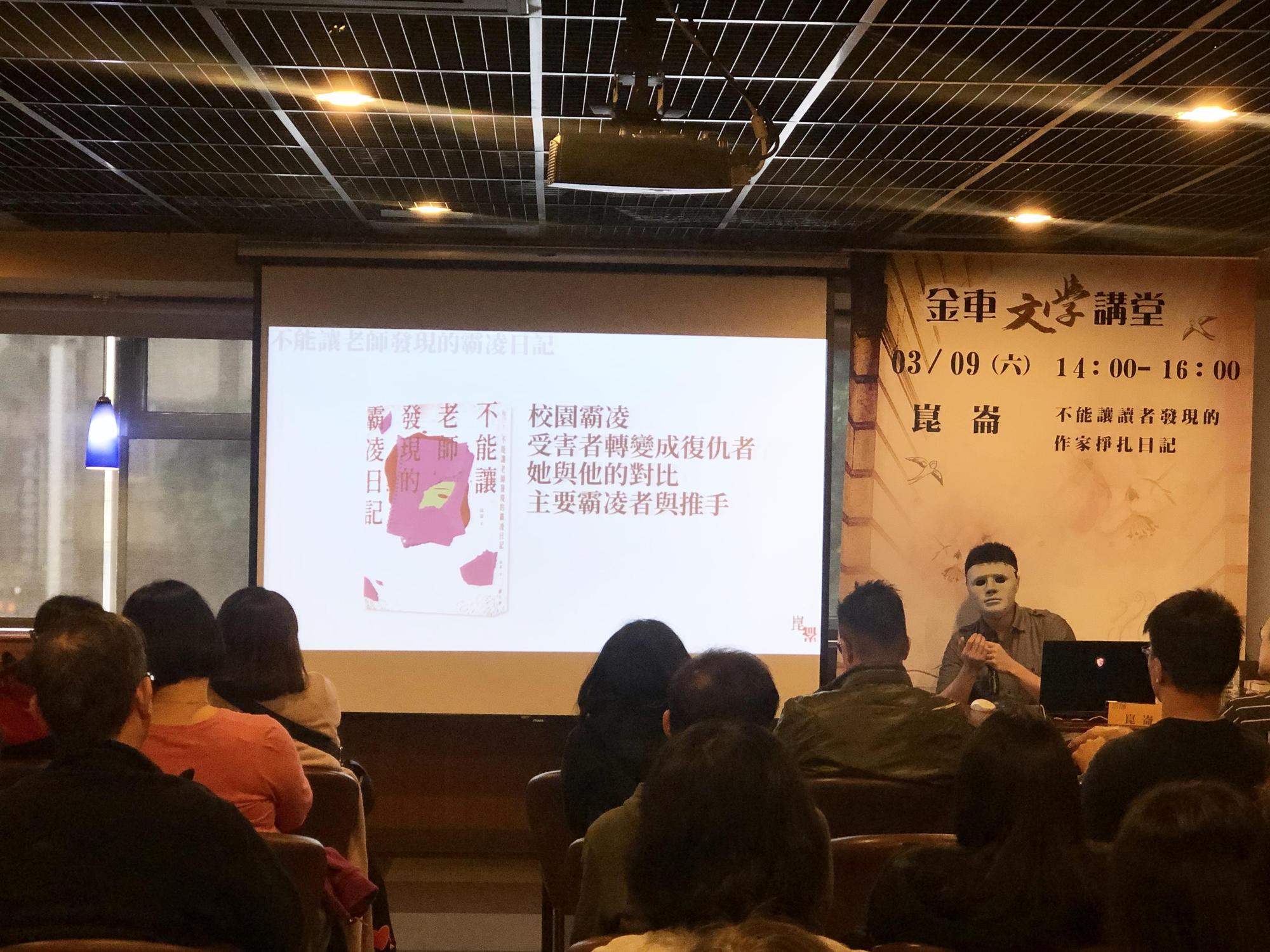 即使出席講座,崑崙依然堅持帶面具,無奇的會場彷彿有傑森出沒。(鏡文學提供)