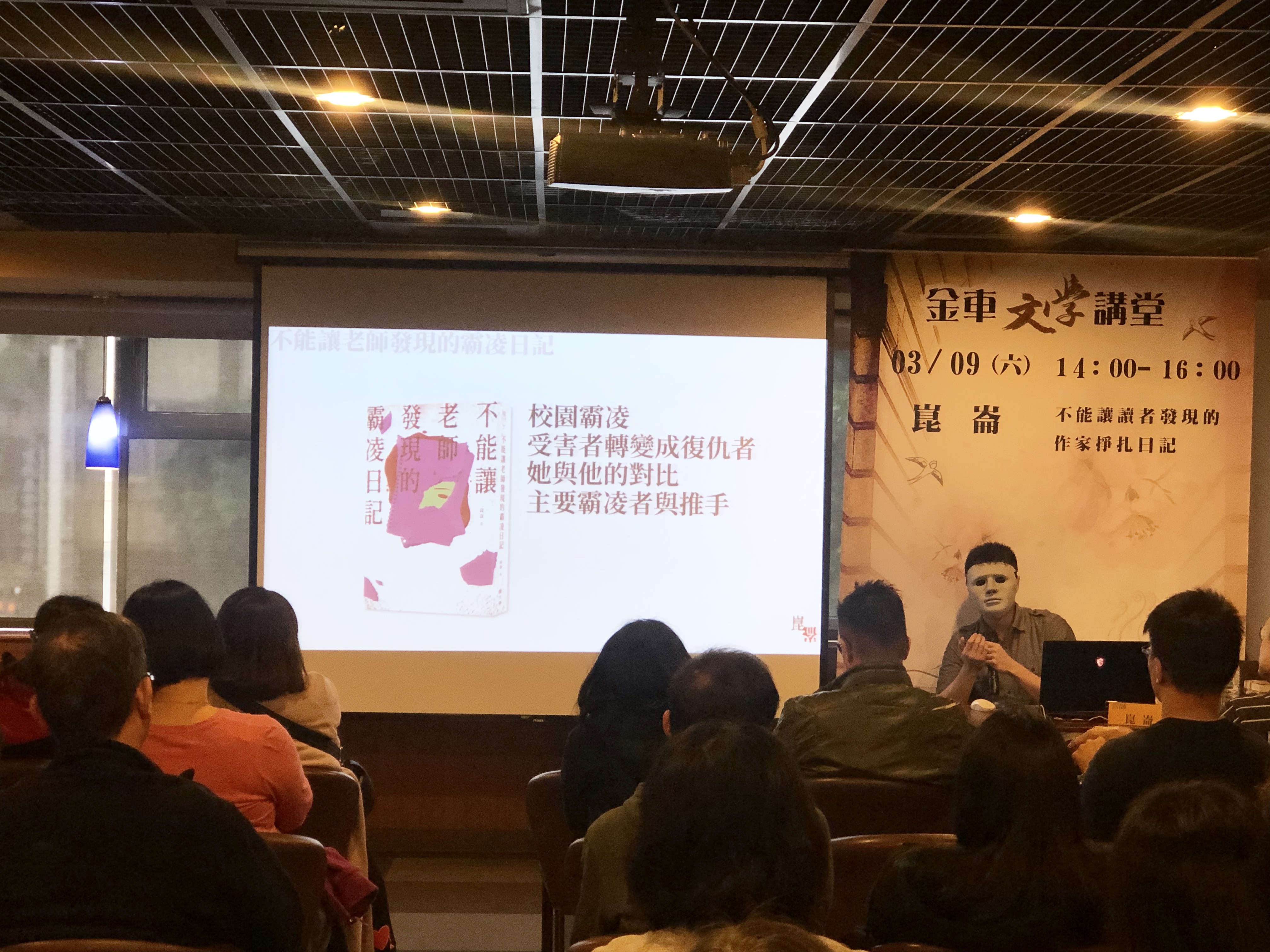 即使出席講座，崑崙依然堅持帶面具，無奇的會場彷彿有傑森出沒。（鏡文學提供）