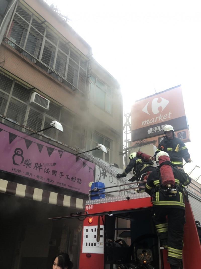 火場3樓一名婦人受困,消防員架梯攻入2樓內,協助脫困。(翻攝畫面)