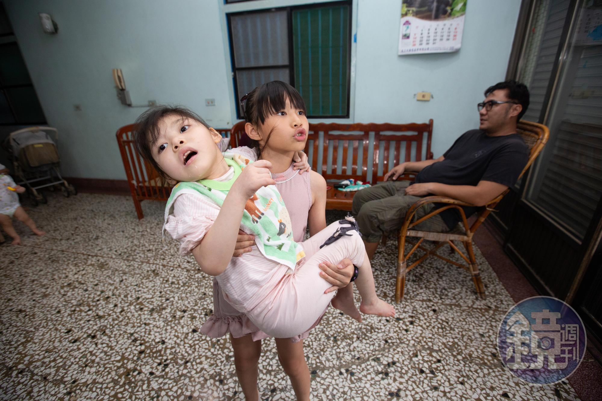  8歲的姊姊董曉樂毫不費力地公主抱起小她1歲的董曉妃，並說4歲開始就能抱起妹妹。