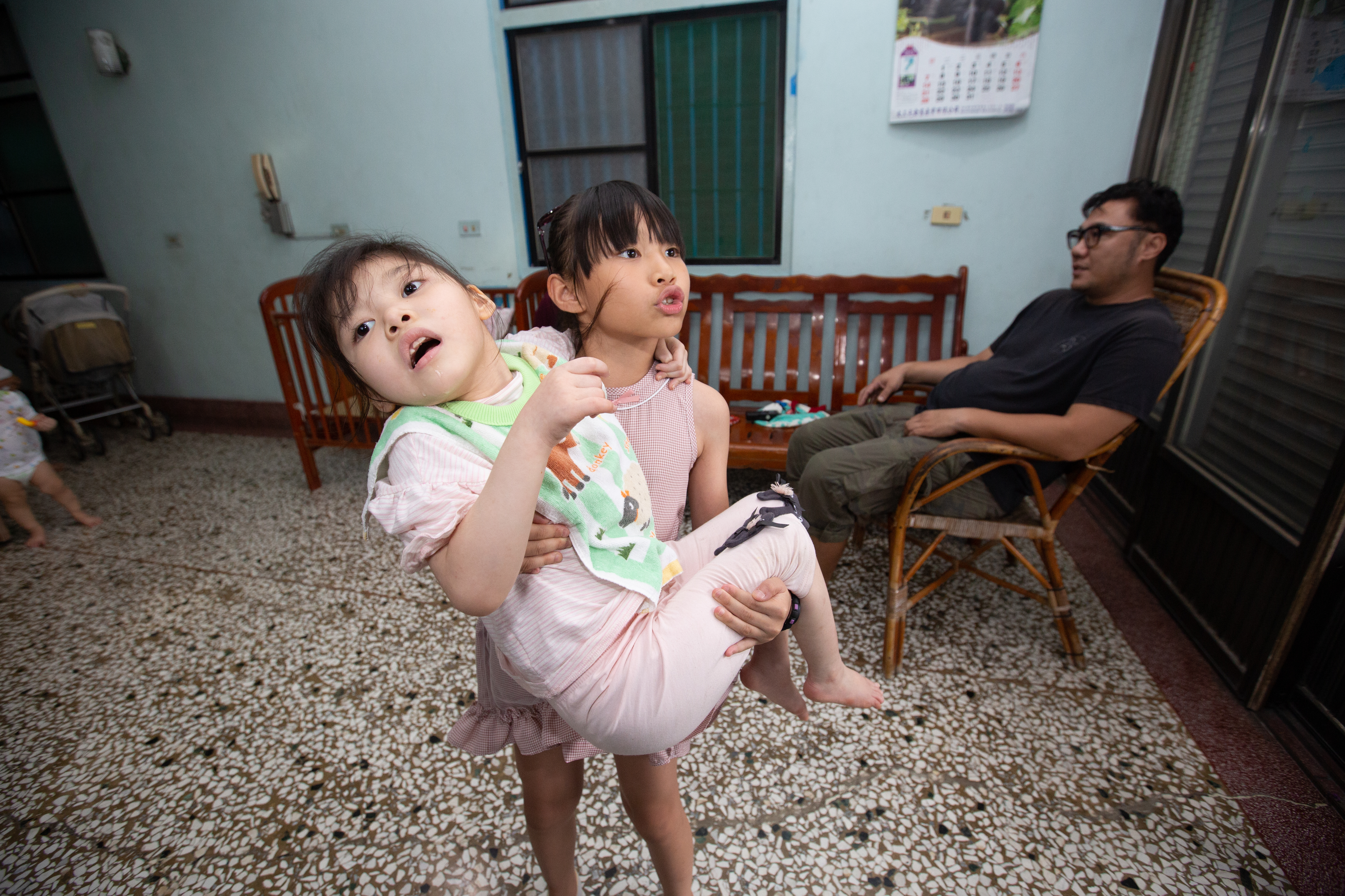  8歲的姊姊董曉樂毫不費力地公主抱起小她1歲的董曉妃，並說4歲開始就能抱起妹妹。