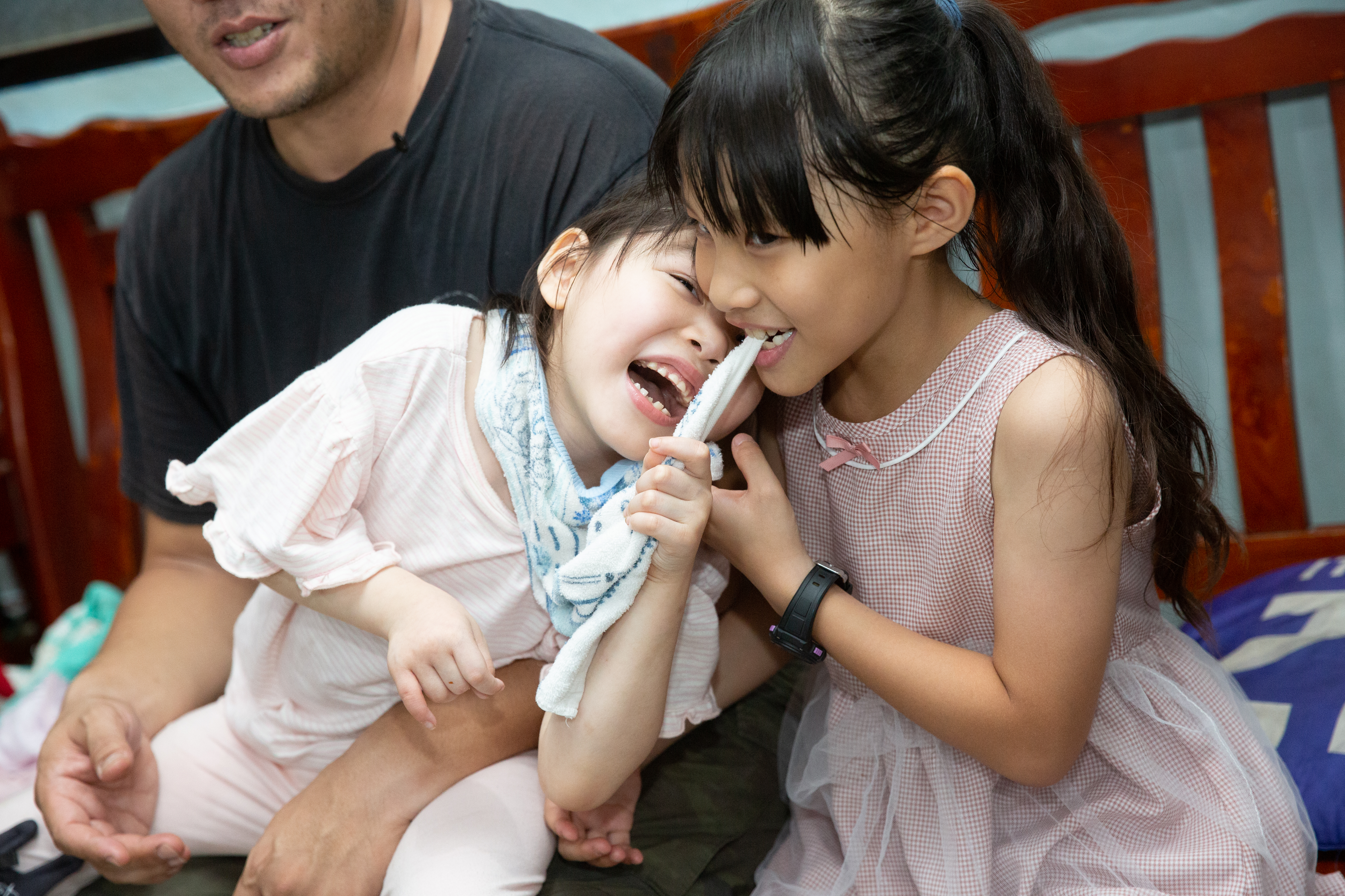 董曉樂咬著妹妹的口水巾，2人嬉鬧笑得無憂。