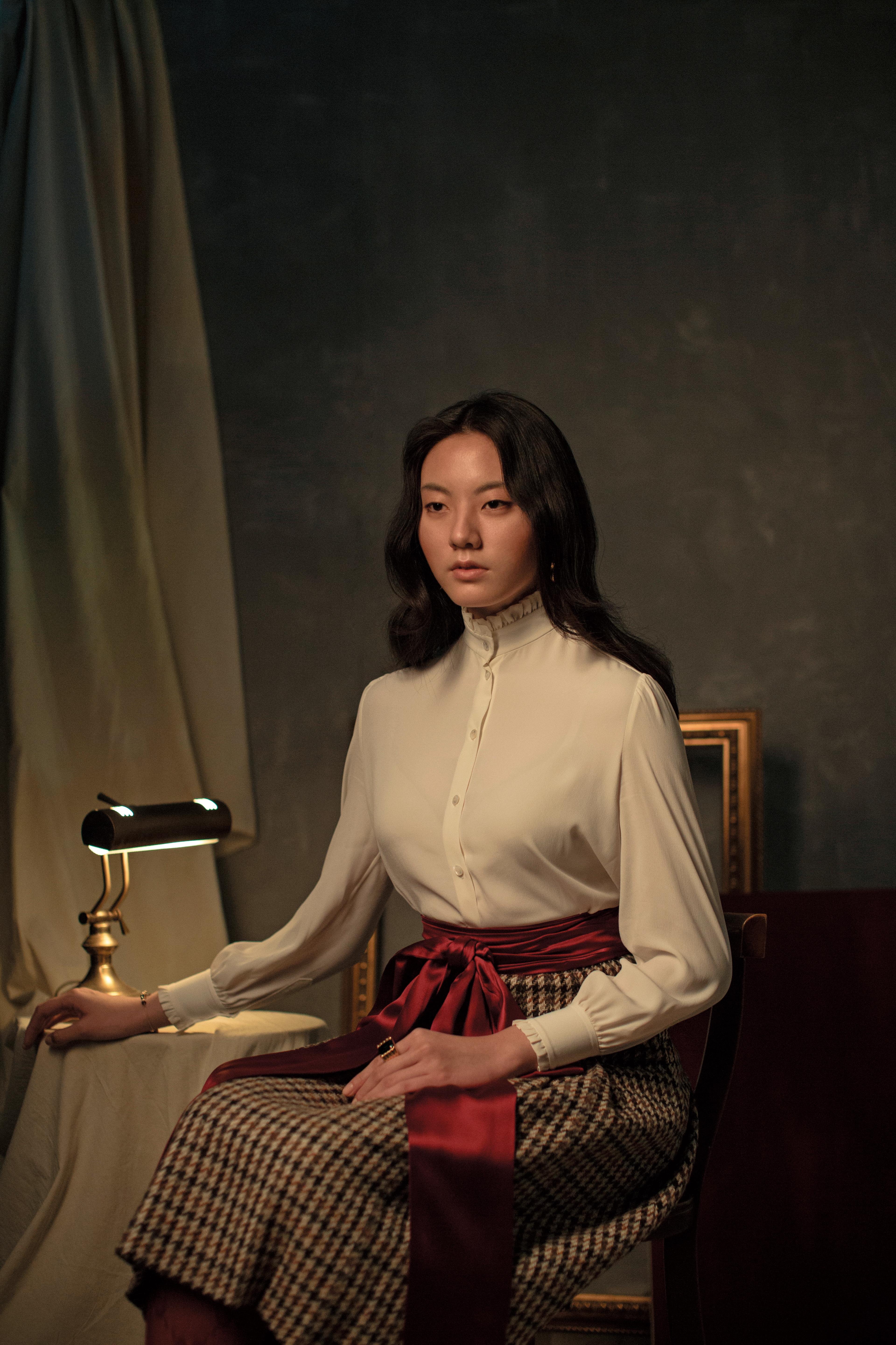 白色立領襯衫 NT$33,000 by CELINE／紅色腰封 價格未定 by GUCCI／棕色千鳥格紋毛呢裙 NT$84,000 by CELINE／Logo圖案過膝襪 NT$4,100 by GUCCI／Tarot Magic鍊飾 NT$4,990 by SWAROVSKI／綠色鋯石鍍金純銀戒指 NT$32,200 by BOTTEGA VENETA