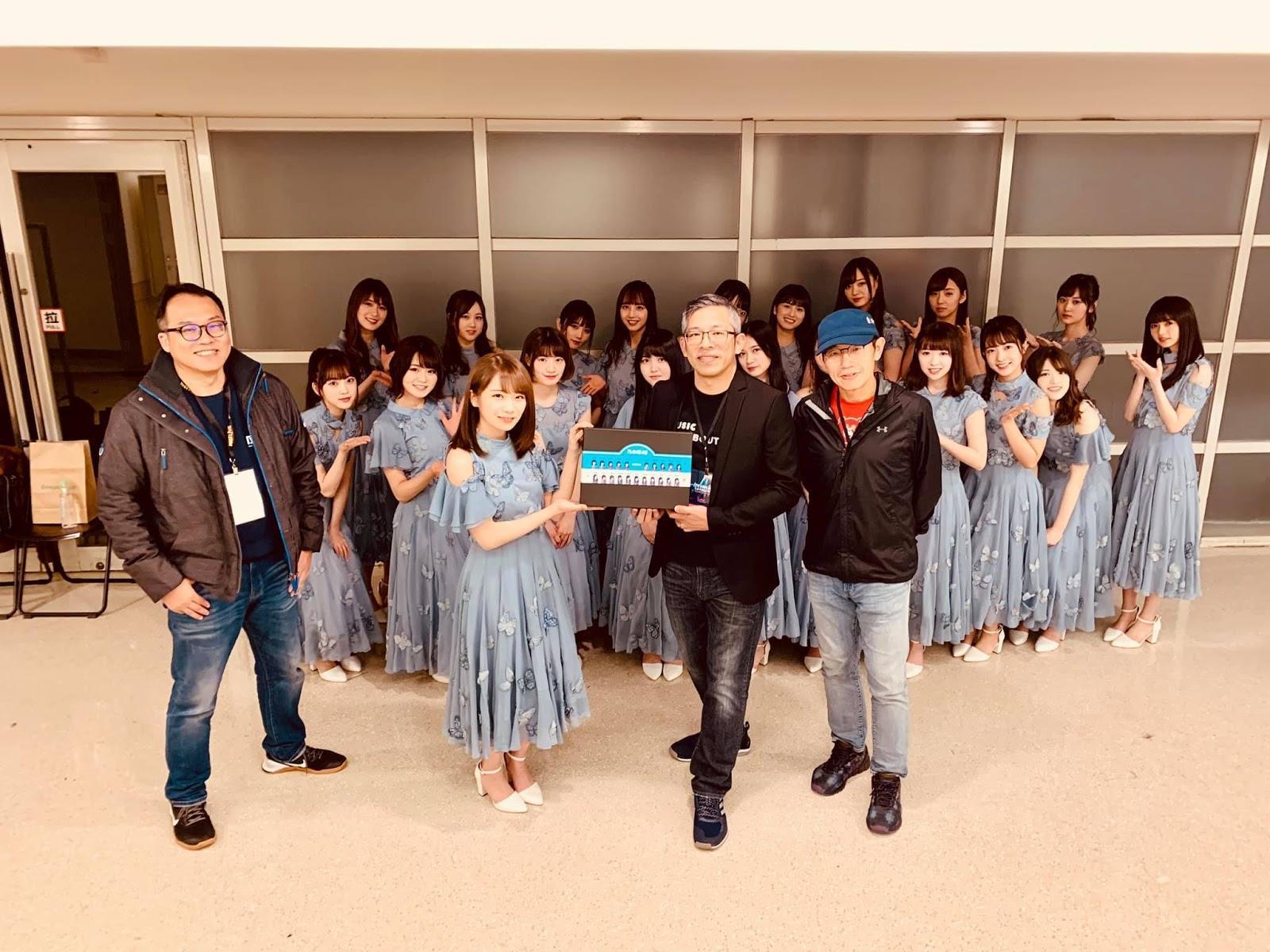 秋元真夏(前排左2)代表乃木坂46,從KKBOX亞太區董事總經理施盈良(前排右2)手中獲贈印有團員肖像的客製化Q版胸章。
