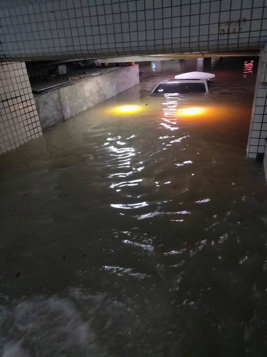 大樓地下室淹水，車輛慘遭滅頂。（翻攝畫面）