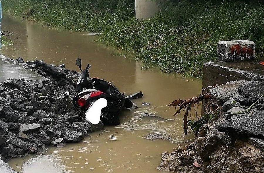 高雄市岡山區林姓女騎士上班途中遭大水沖走，現場遺留機車。（翻攝照片）