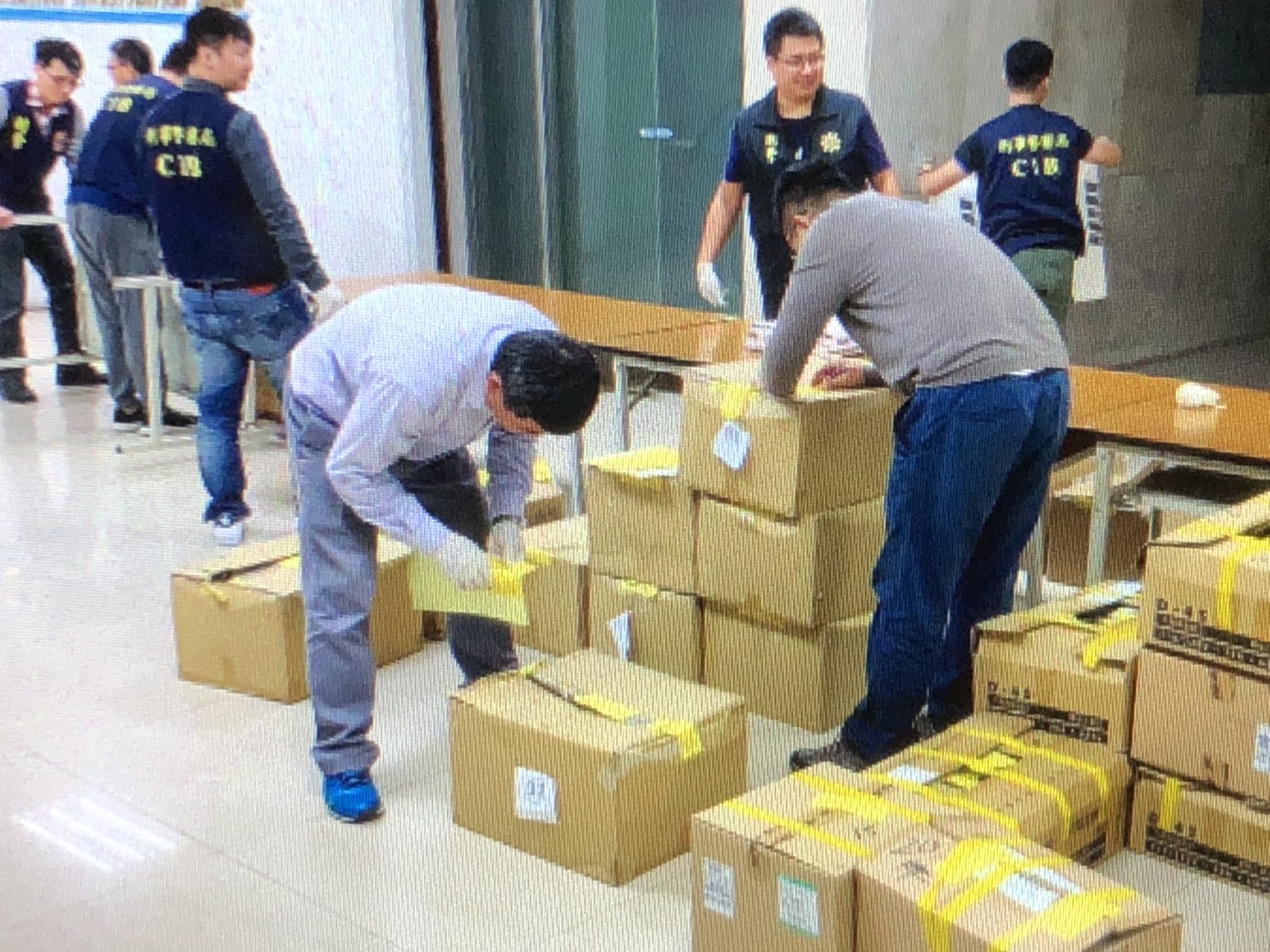 警方去年召開破案記者會，呂嫌（前方低頭者，藍鞋）還在現場協助整理資料。（刑事局提供）