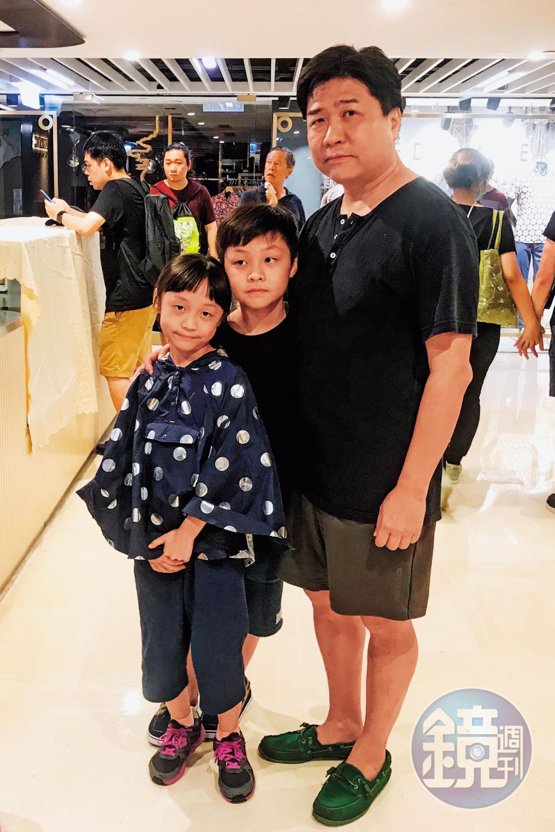 49歲的吳丹尼(化名)與參加遊行的一對兒女。