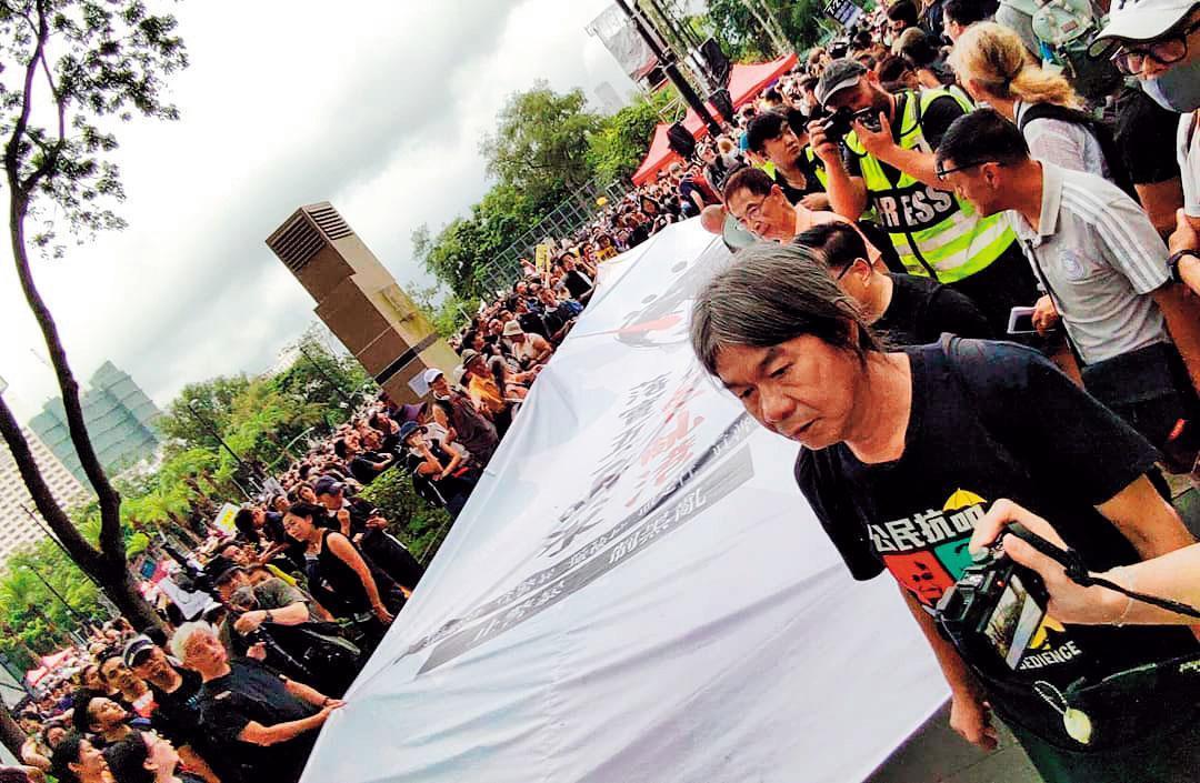 在818集會後的遊行中,前立法會議員「長毛」梁國雄一直走在隊頭。(翻攝梁國雄臉書)