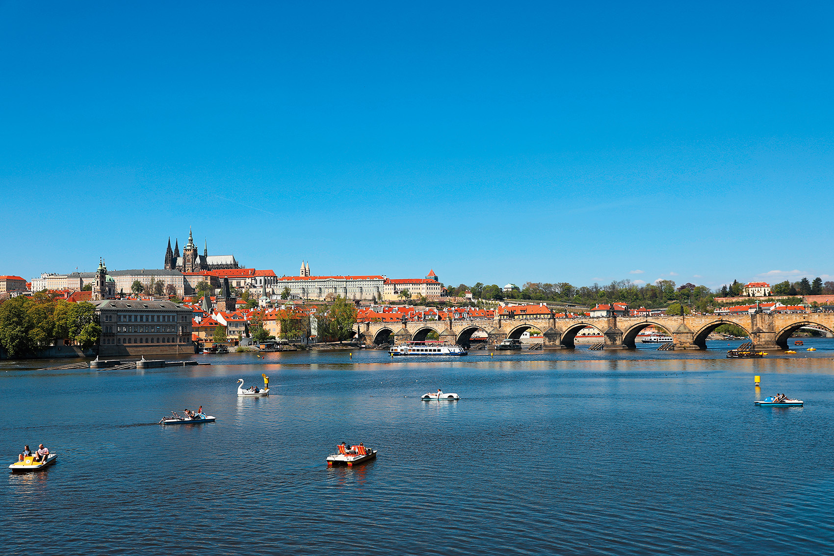 沿著伏爾塔瓦河畔漫步，可以遠眺城堡區與充滿傳說的查理大橋。