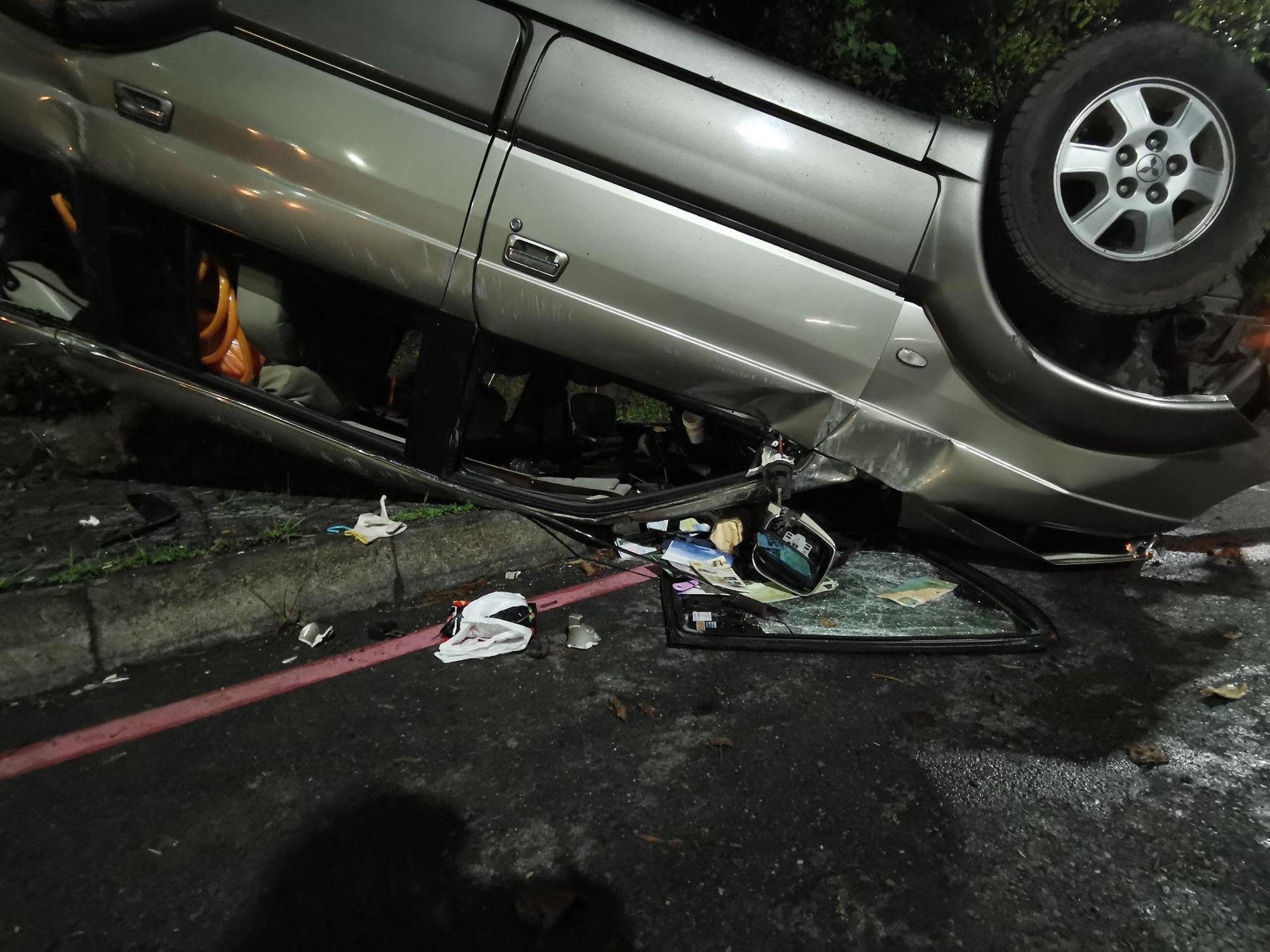 汐止康寧街20日深夜發生休旅車自撞山壁後翻覆事故。(翻攝畫面)