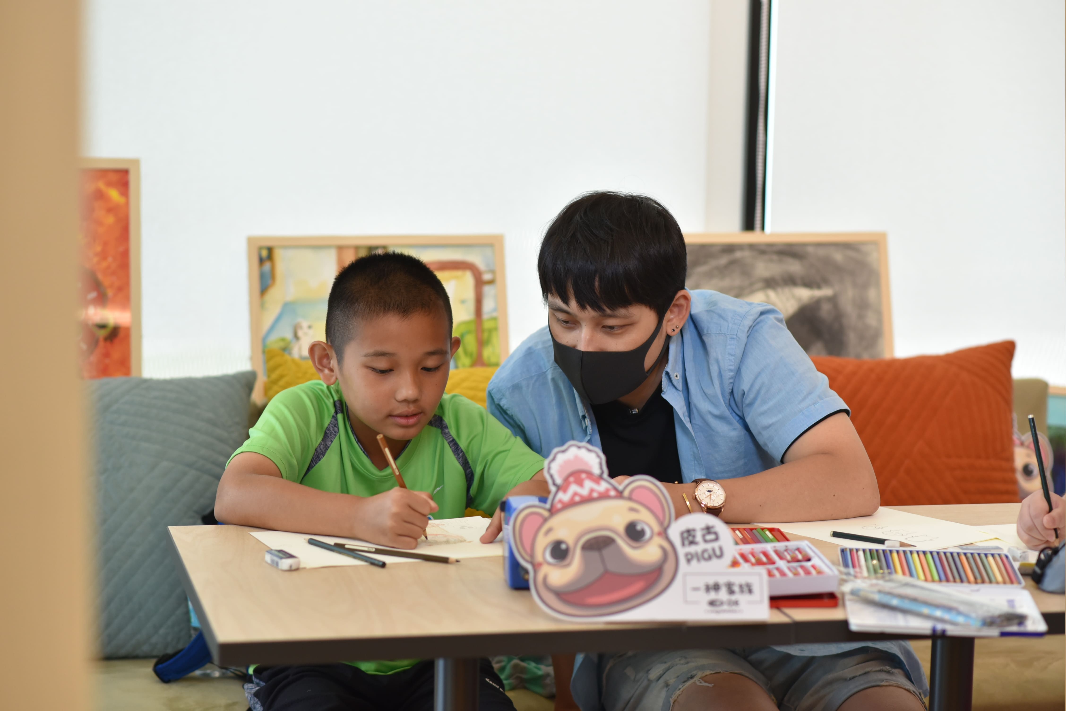 三位知名貼圖畫家與受兒福資助的六位孩童共同創作公益貼圖，雙方從忐忑到熟悉，留下珍貴情誼。圖為畫家一神與孩子奕程共畫貼圖。（LINE提供）