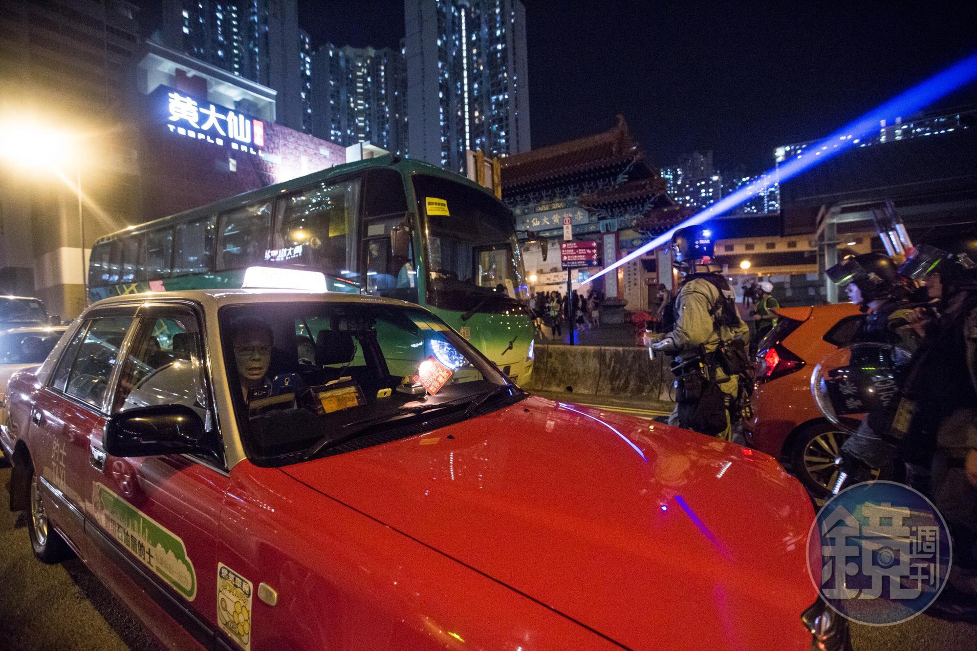 警方於黃大仙龍翔道上的車陣中追逐逼退示威者。