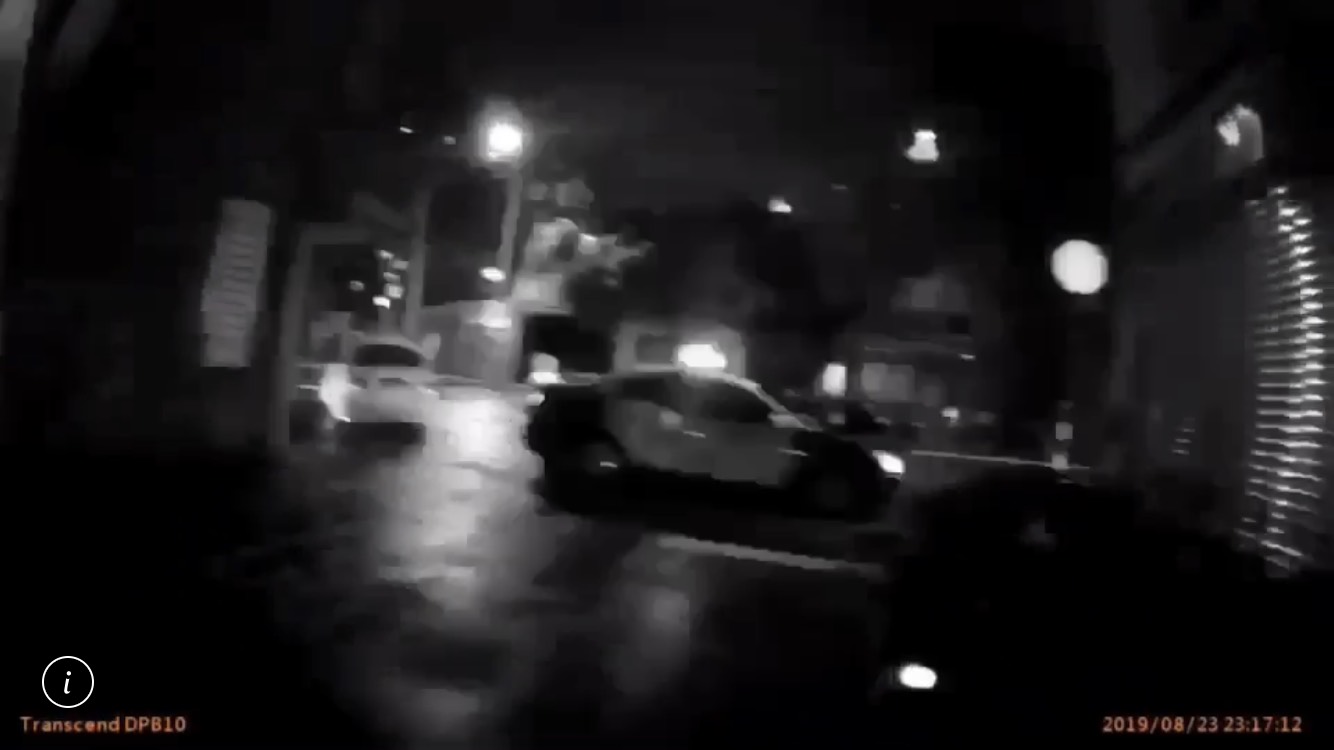 疑似擄人的白色轎車從巷弄內竄出，企圖衝中執勤員警，遭警開一槍後逃逸。（翻攝畫面）