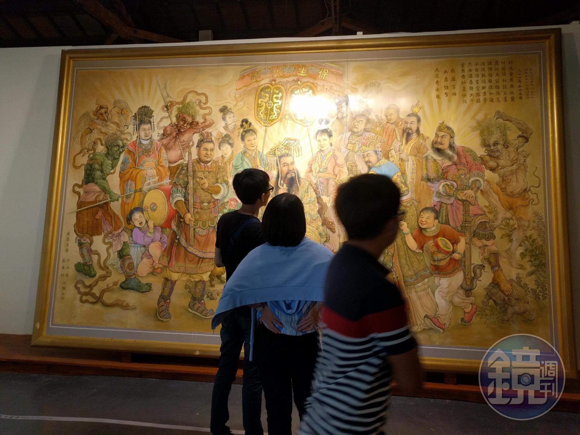 「近未來的交陪」展覽裡，陳秋山在檜木版上創作的《保生大帝群仙會》，突破過往廟畫直接畫在牆上，易被燻黑也難以修復，讓珍貴的廟畫更易於保存。