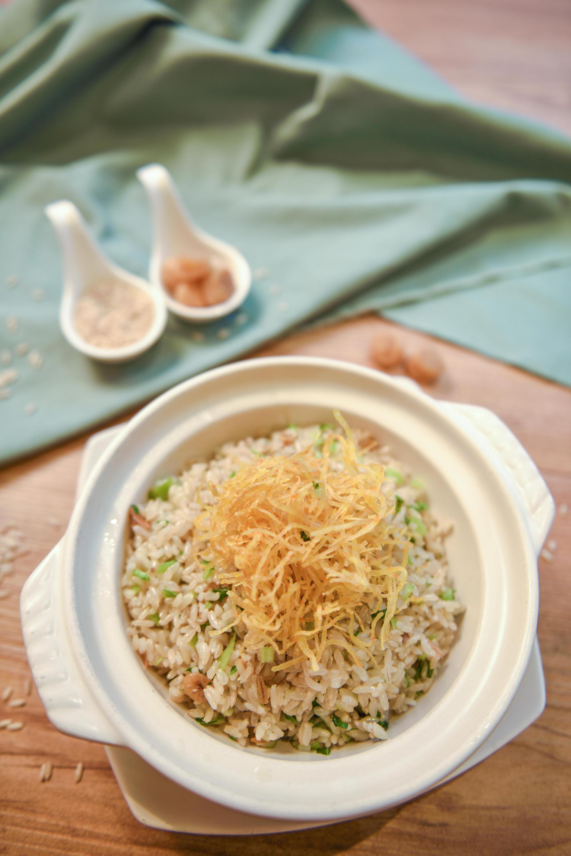 「湧泉米干貝菜飯」口感略為濕潤，米粒飽實有Ｑ度，拌著干貝絲一起入口更鮮美。（280元／份，照片由瓏山林台北中和飯店提供）
