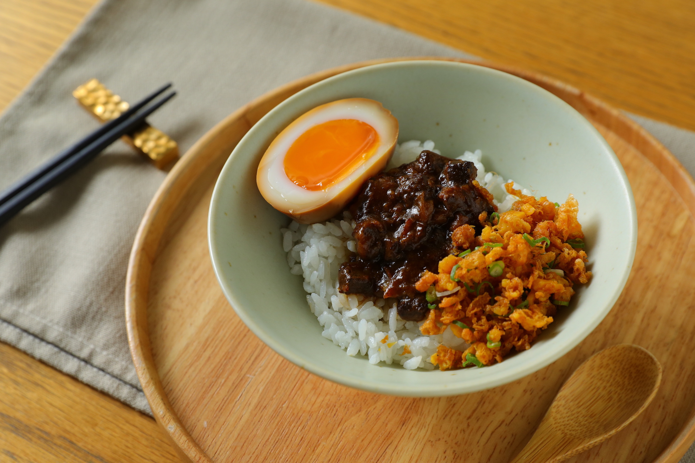 「好吃的飯」有古早味肉臊與烤鹹蛋黃碎、蛋酥及溏心蛋，是必點主食。（100元／碗）