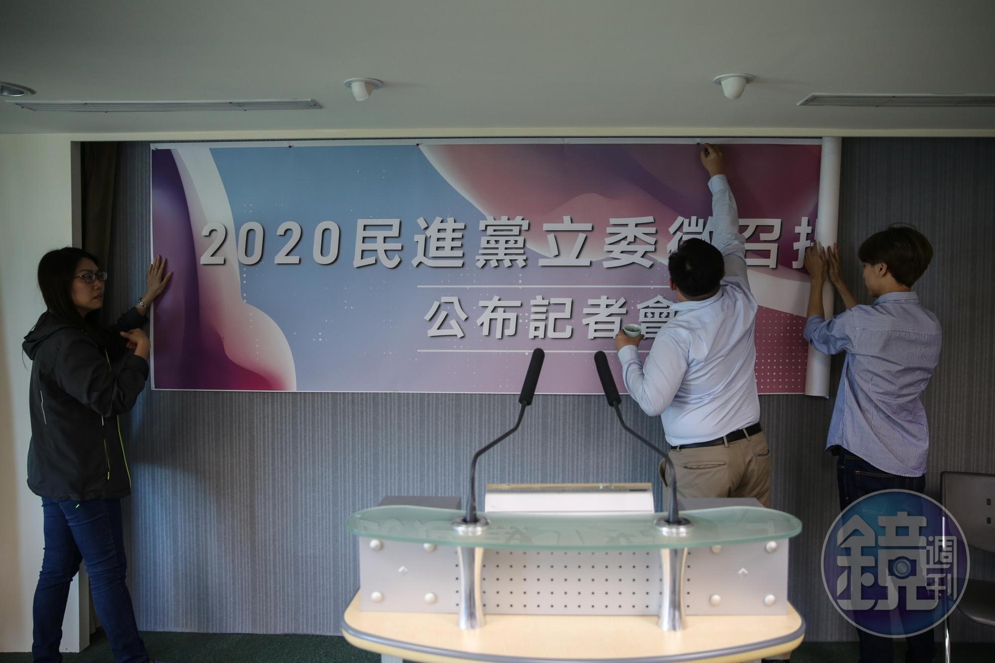 中執會流會後,黨工尷尬地拆下立委徵召記者會的海報。