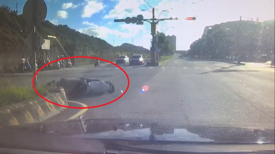 薛員機車倒地滑行衝撞上路口分隔島，巨大的撞擊力道造成薛員場失去意識。（翻攝畫面）