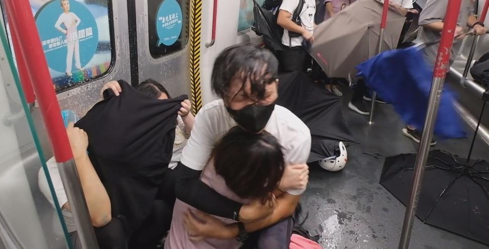 香港市民搭乘地鐵時遭警方以胡椒噴霧和警棍無差別攻擊。（翻攝梁柏堅臉書粉絲專頁影片）