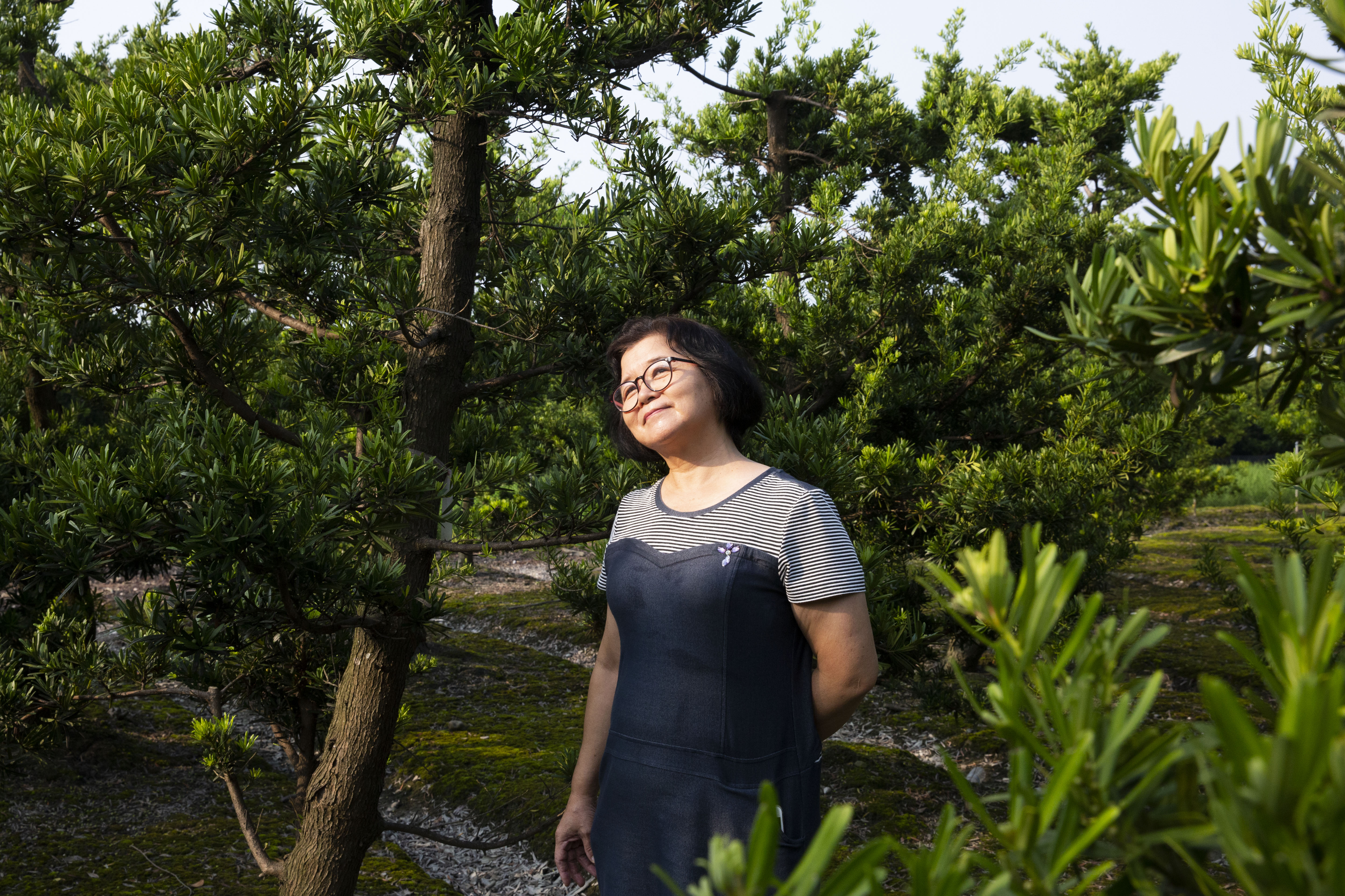 張錦雲走在自家的田裡，辛苦大半輩子，她已不擔心兒子的未來，說人生的一切都是緣份。