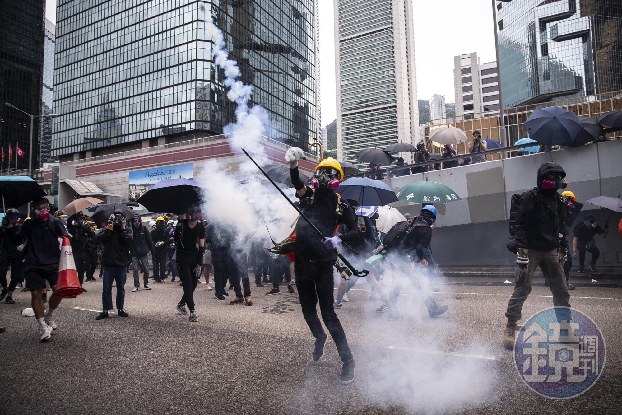 港警的手段日益狠辣，發射催淚彈、橡膠子彈、布袋彈的數量已突破歷史紀錄。前線勇武派只能以簡易方式抵抗，圖為示威者回擲催淚彈。（攝影：陳朗熹）