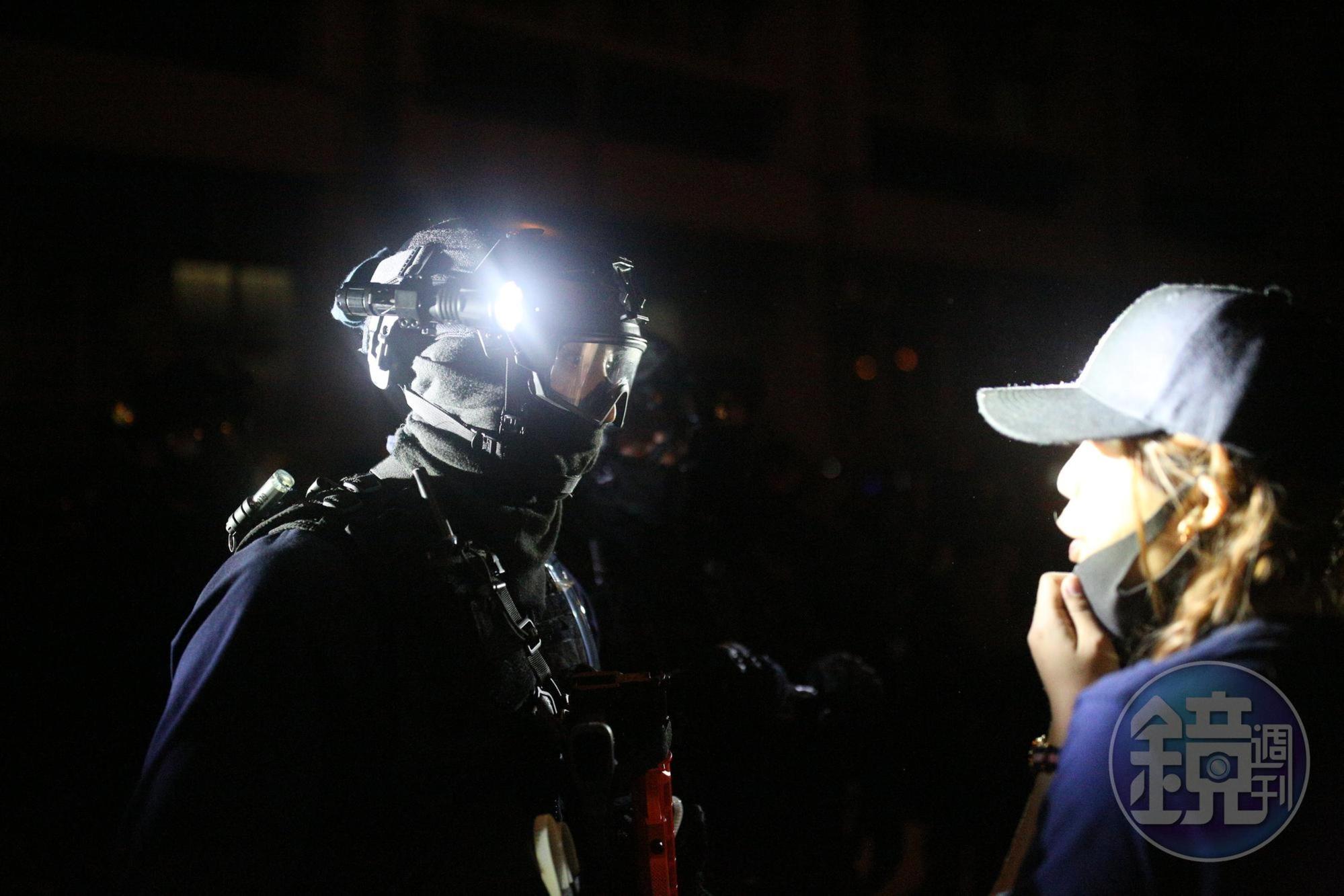 倖存者在黑夜中與速龍隊警員相視。