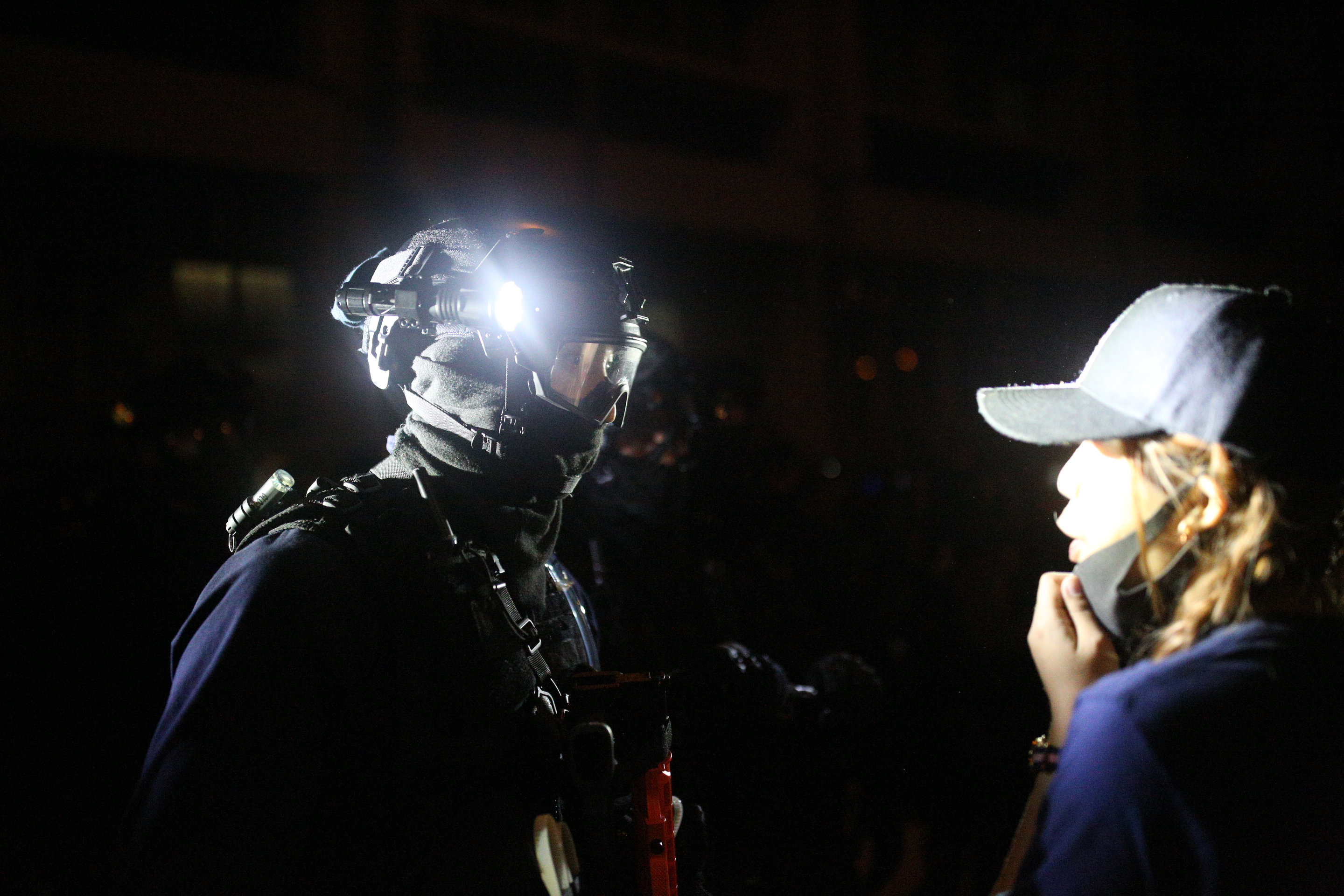 倖存者在黑夜中與速龍隊警員相視。
