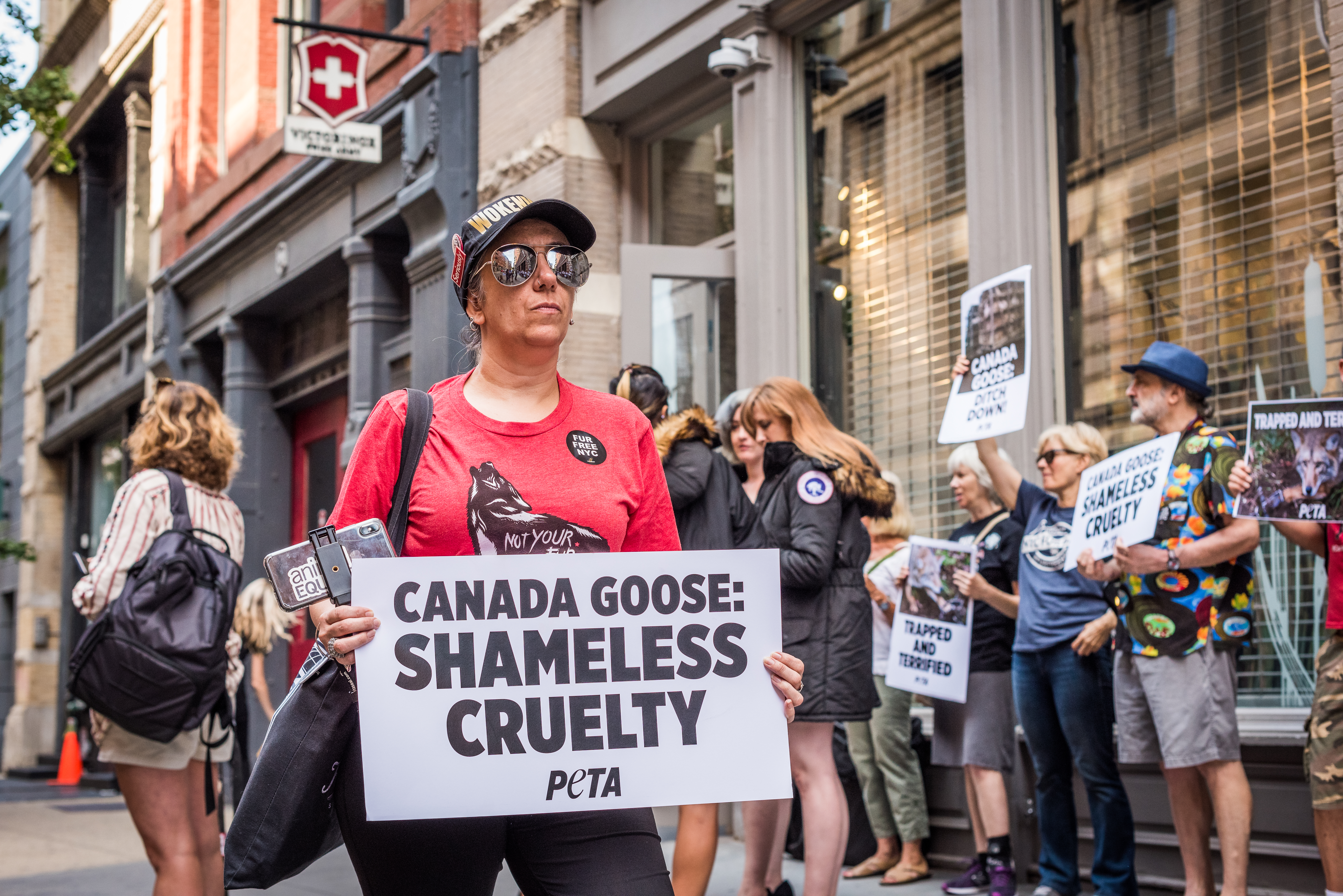 加拿大精品廠牌Canada Goose因涉虐待動物，遭人在股東會場外持標語抗議。（東方IC）