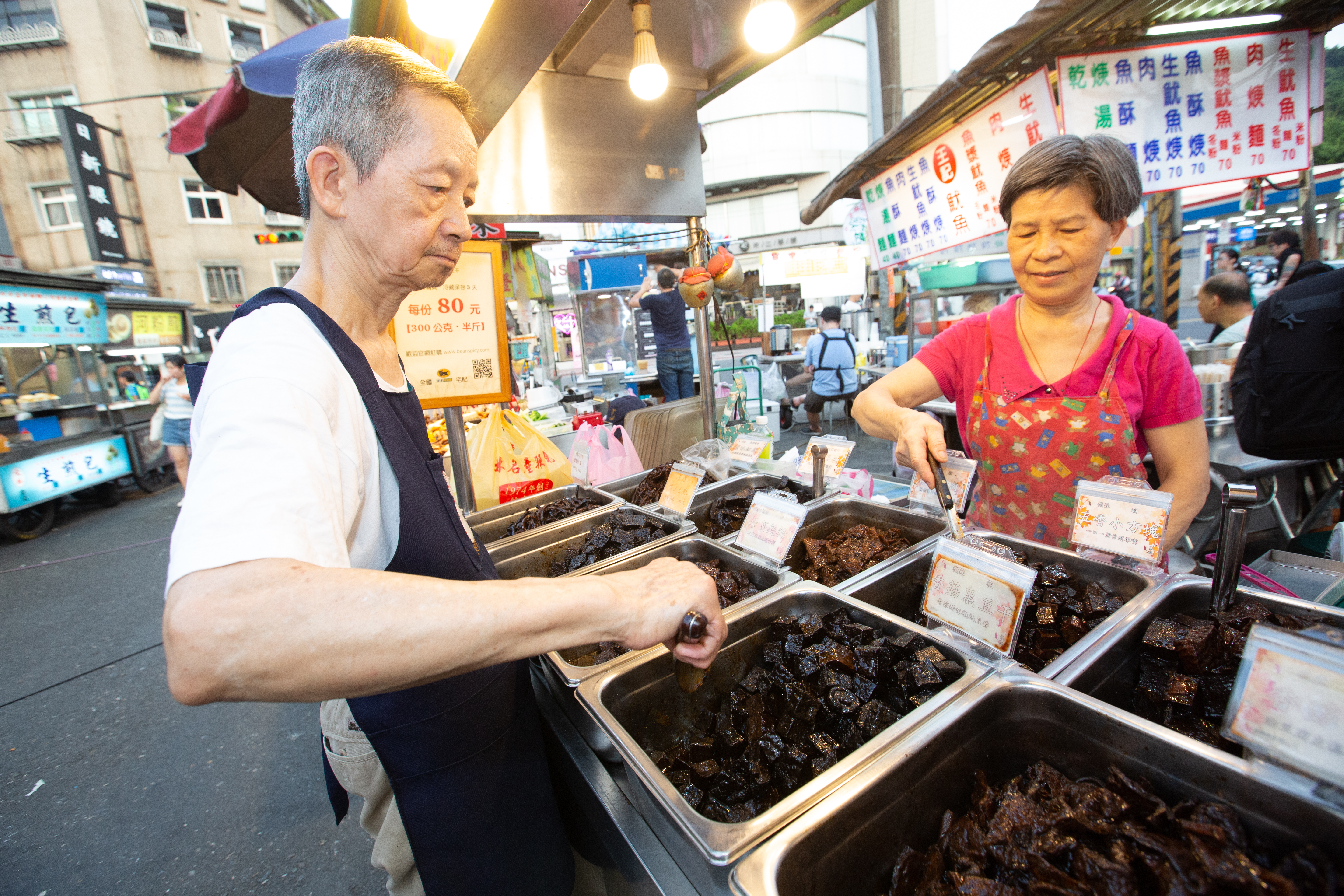吳長生（左）與妻子黃屘45年前創立吳家豆干，現在吳長生主要負責滷製，妻子負責顧攤販售。