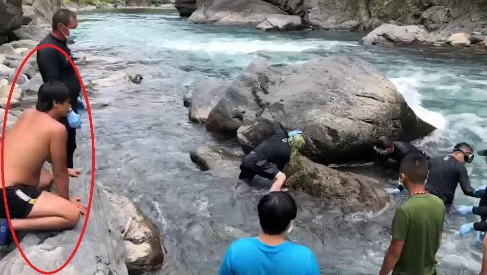 6歲簡姓男童在南勢溪拉模基橋下水域失蹤10天後,今日被發現卡在岩縫中,父(紅圈中人)則在岸邊呼喚兒子回家。(翻攝畫面)