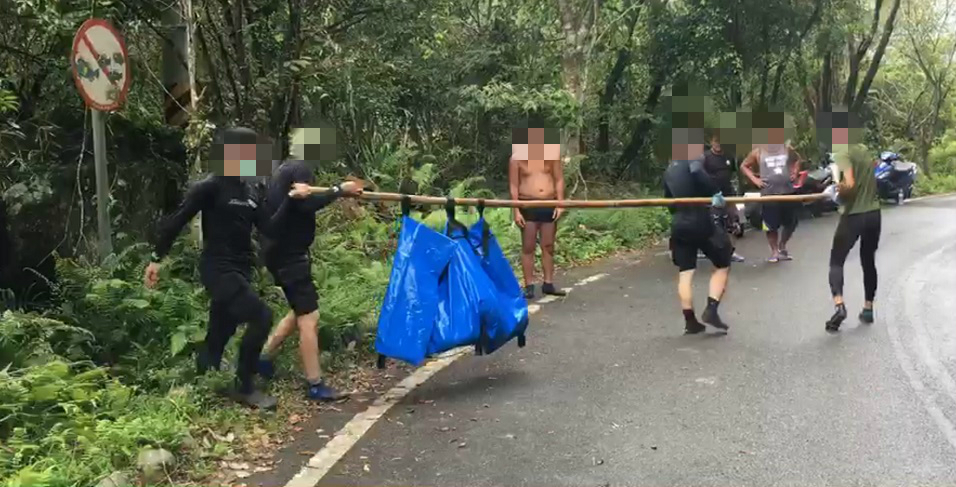 搜救人員費盡力氣才將男童從溪水岩縫中拉出，並送上岸等待檢警相驗。（翻攝畫面）