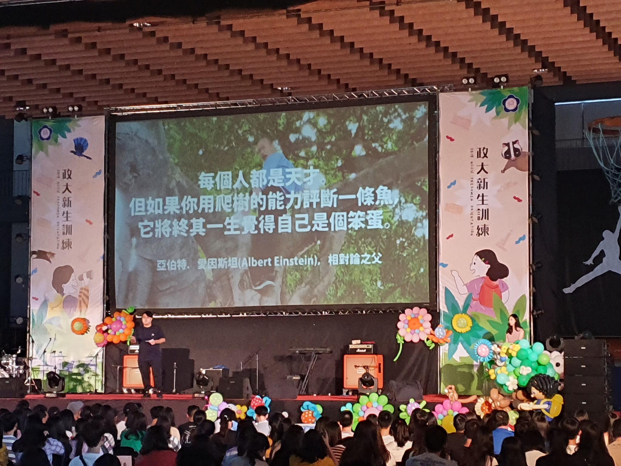 政治大學昨（4日）舉辦108學年度新生訓練，學生會長致詞時竟出現「韓國瑜爬樹」照，引起熱議。（翻攝自行走的故事詩/yanwu臉書）