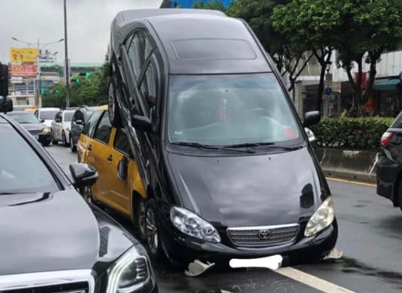 黑色轎車疑因踩踏油門不慎，先撞上前方車輛，再高速後退騎上後車引擎蓋。（翻攝畫面）