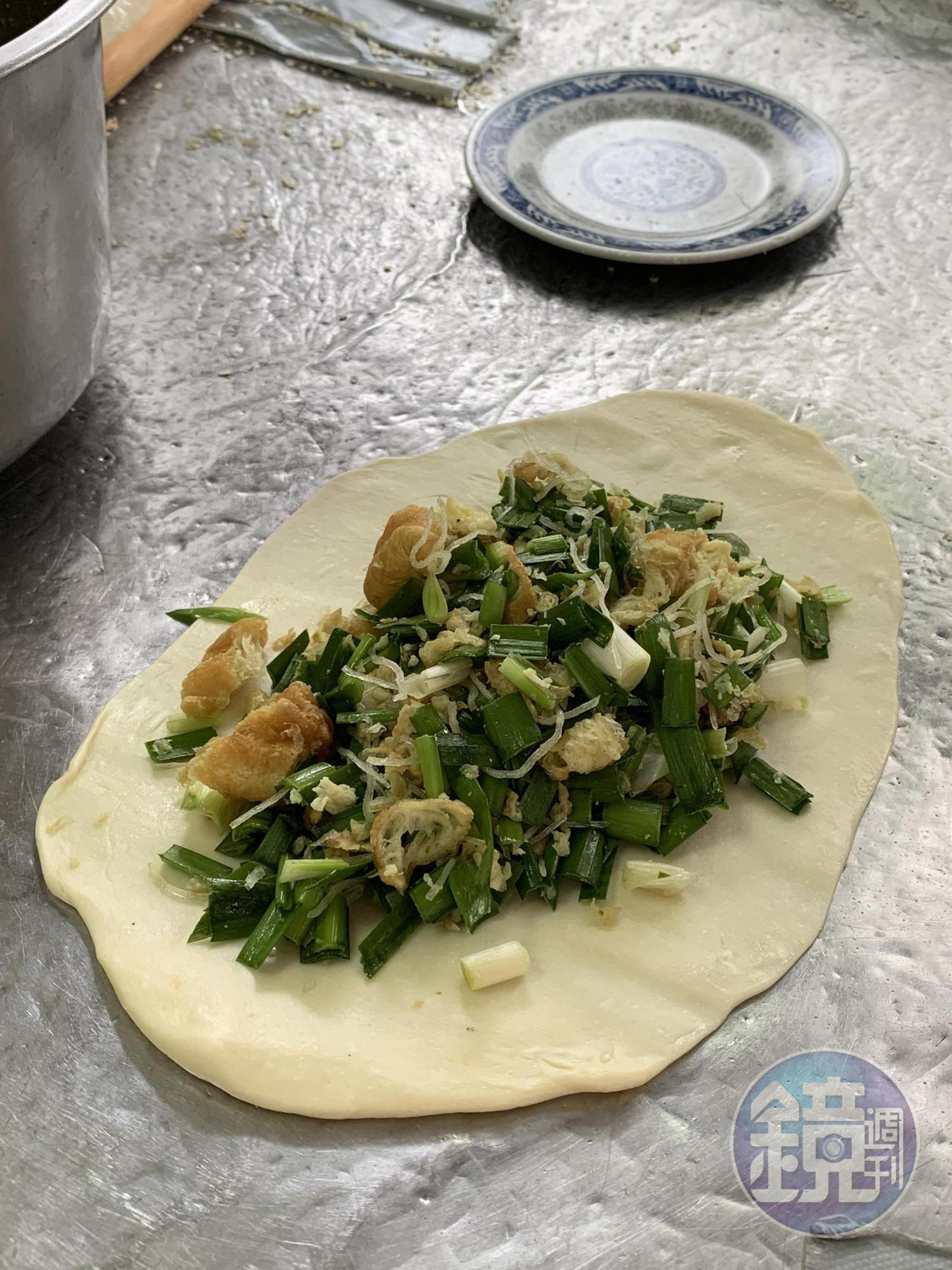 韭菜盒子內餡有韭菜丁、蝦皮、蛋絲、冬粉和油條塊,相當飽滿。